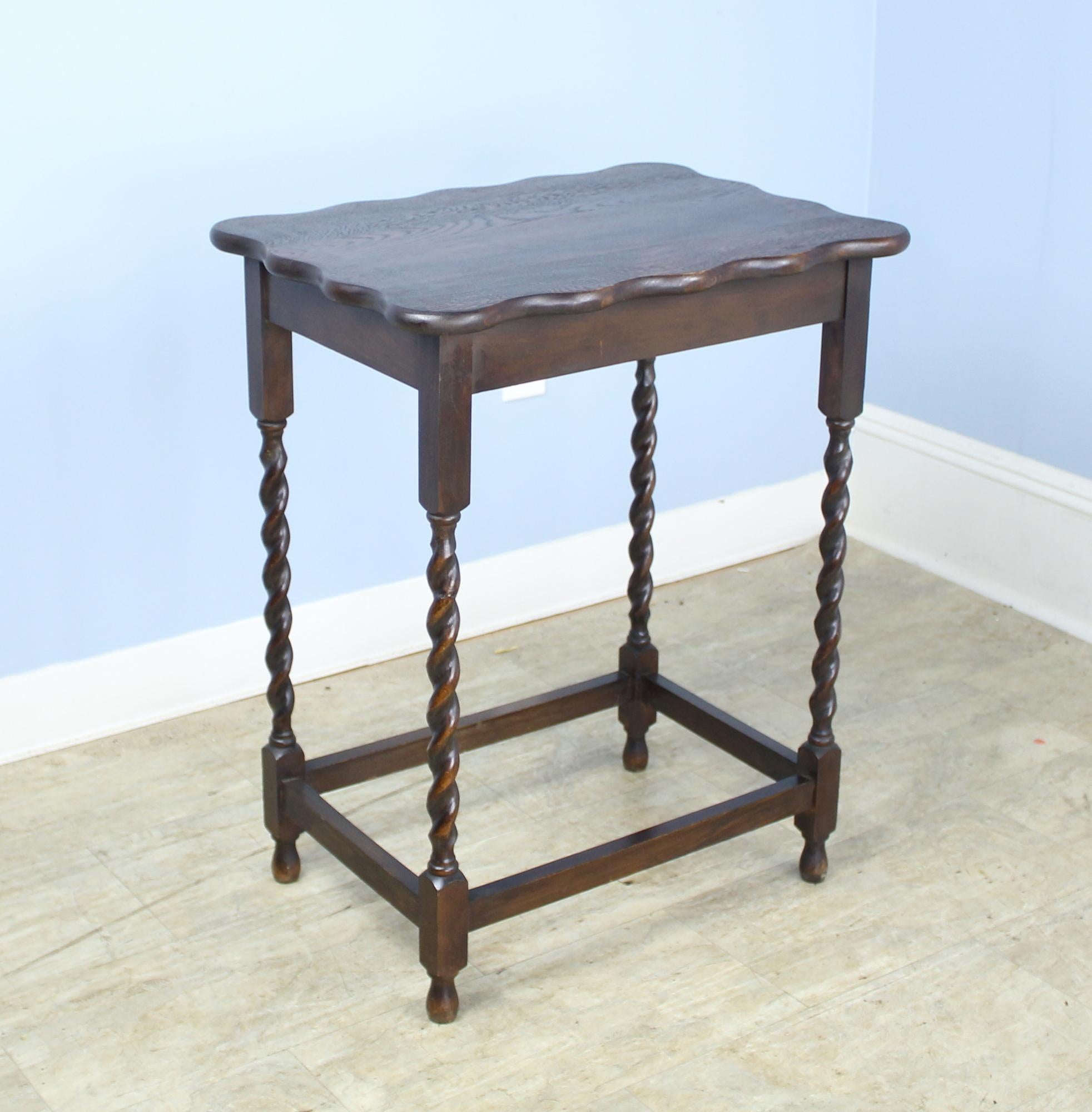 A charming simple occasional table in dark oak with eye-catching barley twist detail. Would make a nice lamp table and would pair nicely on either side of a sofa or guest bed with our other scalloped edge, barley twist side table reference