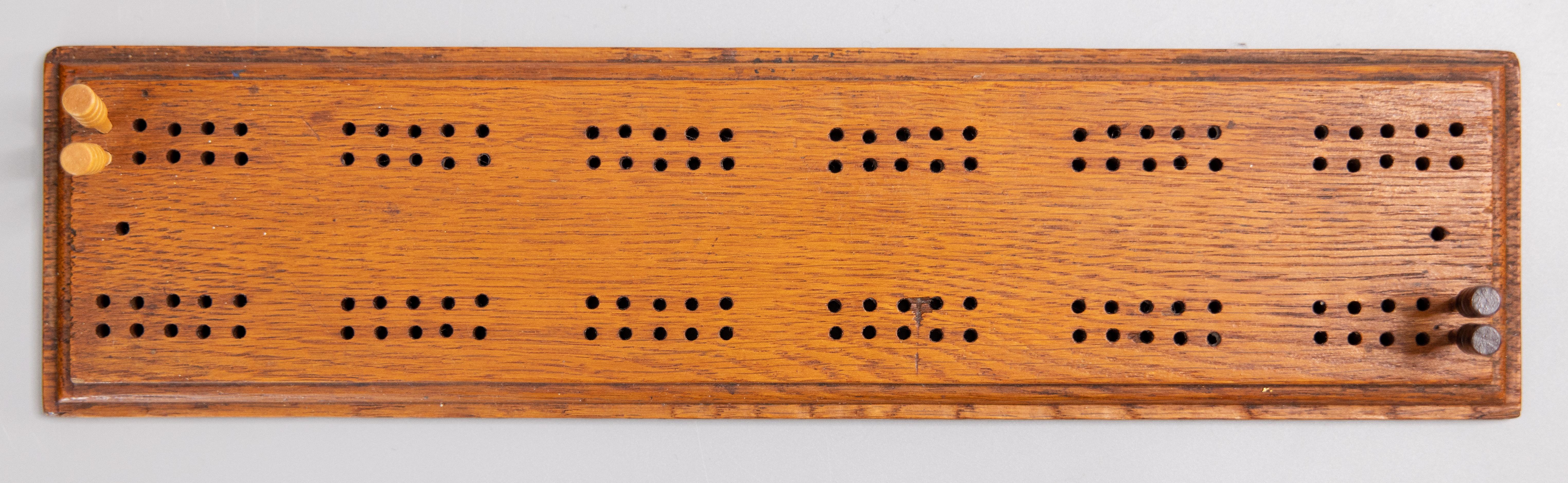 An early 20th Century handmade English cribbage oak game board with beveled edges and 4 pegs, circa 1910. Maker's mark on reverse. It would make a wonderful gift!

DIMENSIONS
12.5ʺW × 3.2ʺD × 0.5ʺH