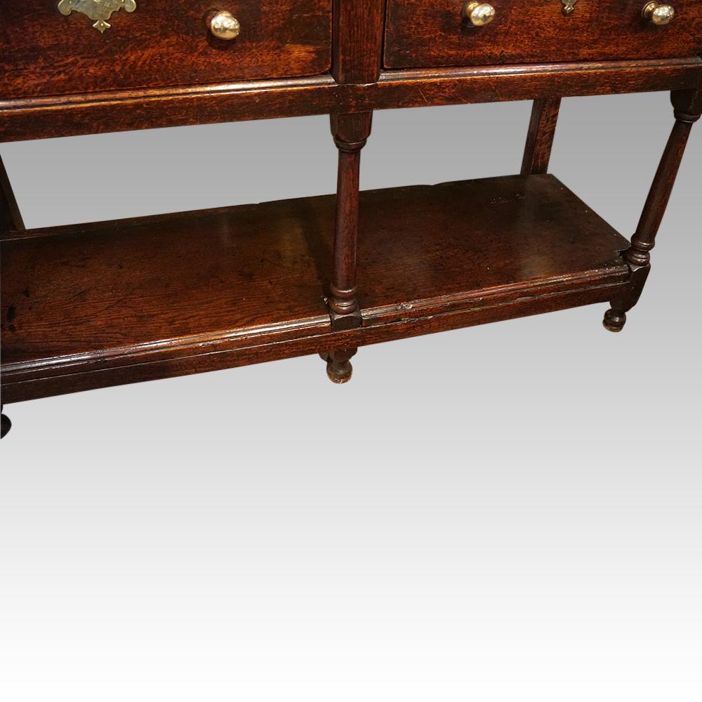 Antique oak pot board dresser base
This Antique oak pot board dresser base was made circa 1820.

It has 2 drawers above the attractive shaped and pierced apron.

The well-turned front legs join the pot board that consists of good deep hand sawn