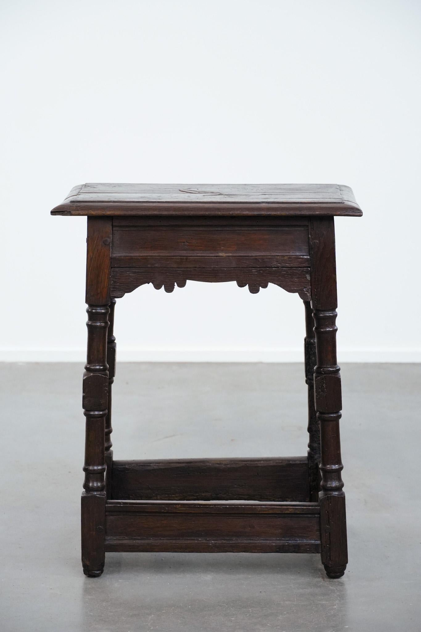 This timeless antique English stool / joint stool / side table from the 18th century combines charm and functionality. Due to its age and years of use, it has acquired a beautiful patina and a warm, characterful, and elegant appearance. It fits