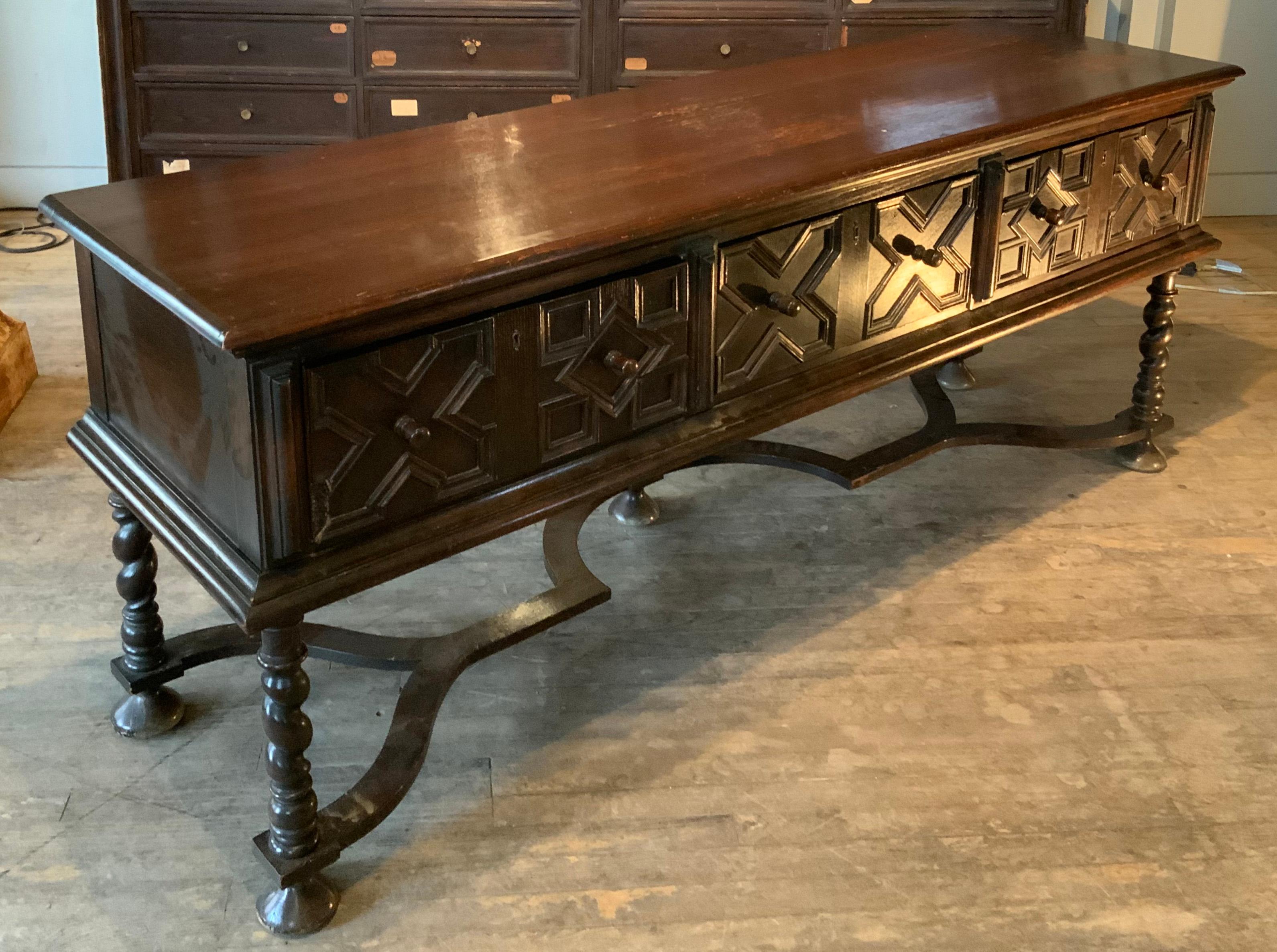 A very handsome 1940s English oak sideboard or console table with amazing barley twist legs. Beautiful design and details, with a curved sculptured stretcher and three large deep drawers along the front. The drawer fronts are detailed with a parquet