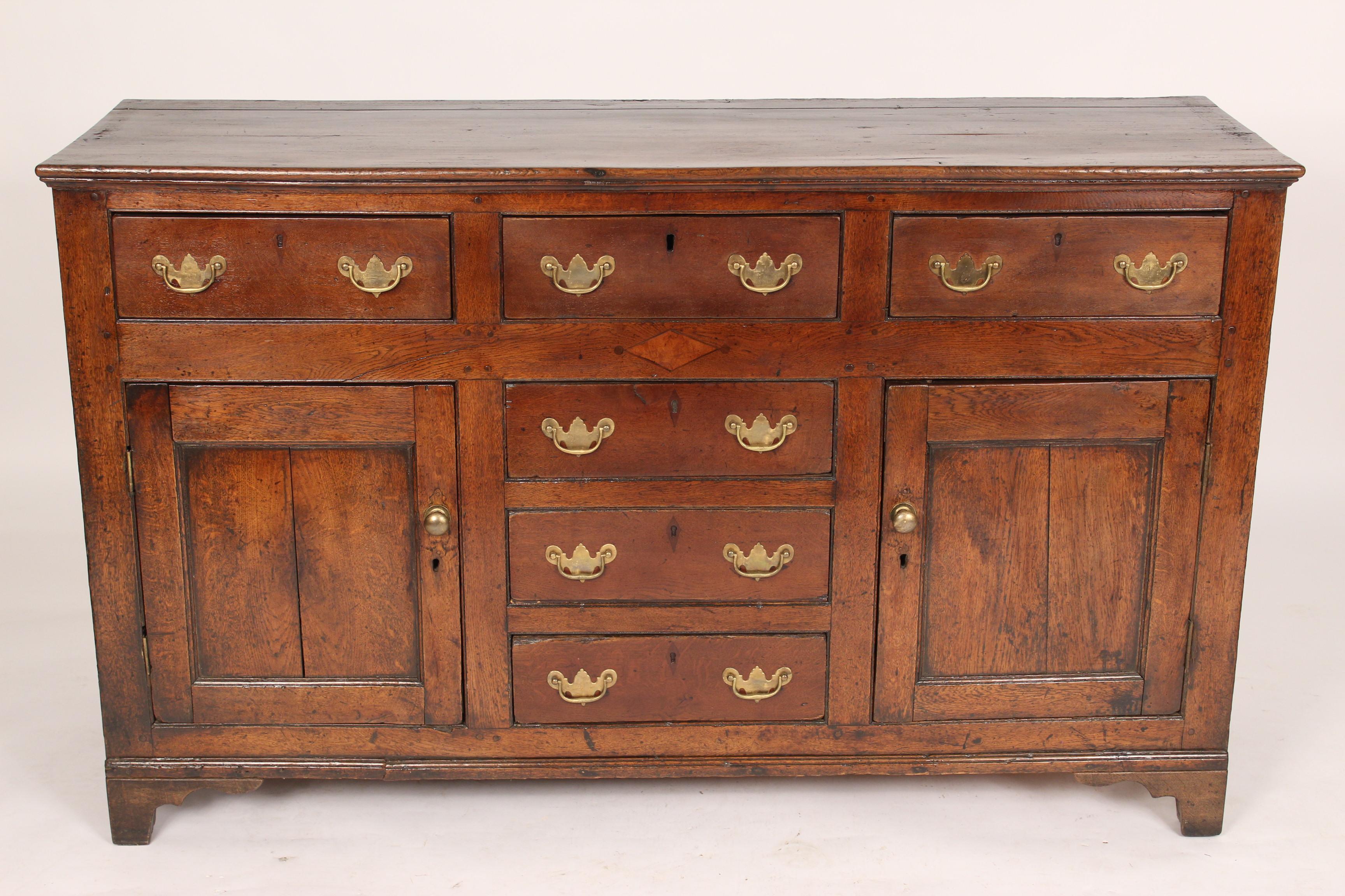 Antique English oak sideboard, 19th century. With two doors and 3 horizontal / frieze drawers. With nice old color. The 3 center drawers are stationary and do not open. No shelves.
