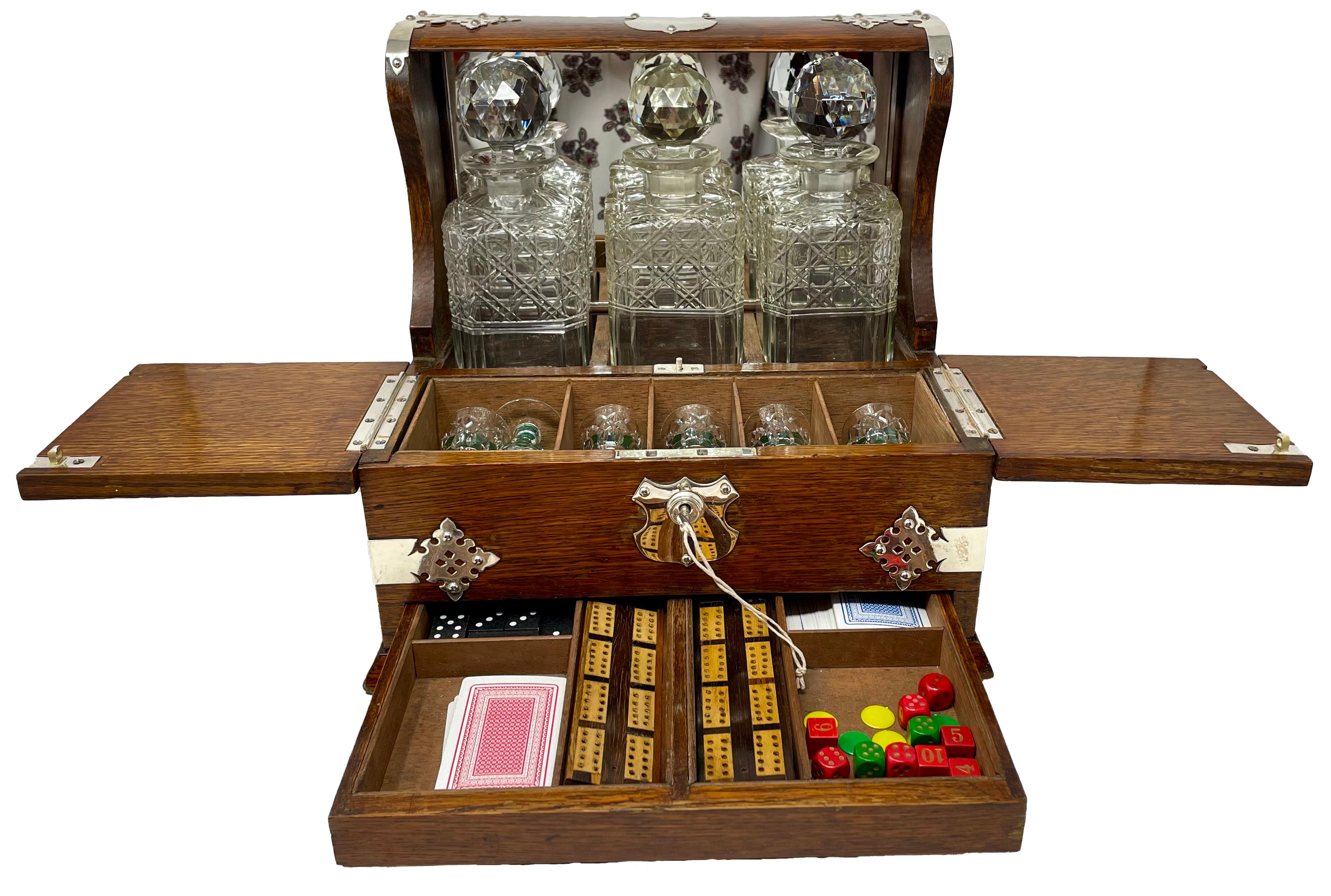 Antique English Silver Plate Mounted Oak Tantalus and Games Compendium Box with 3 Cut Crystal Liquor Bottles, 6 Cordials and Multiple Games.
Closed: 13.25