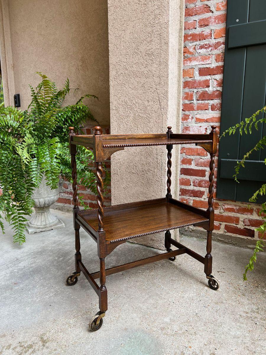 Direct from England, a beautiful antique English oak tea trolley or “dumbwaiter” serving cart.
Excellent for entertaining and great for use as a side table or sofa table.
Features classic English barley twist legs, with ball finials to each post;