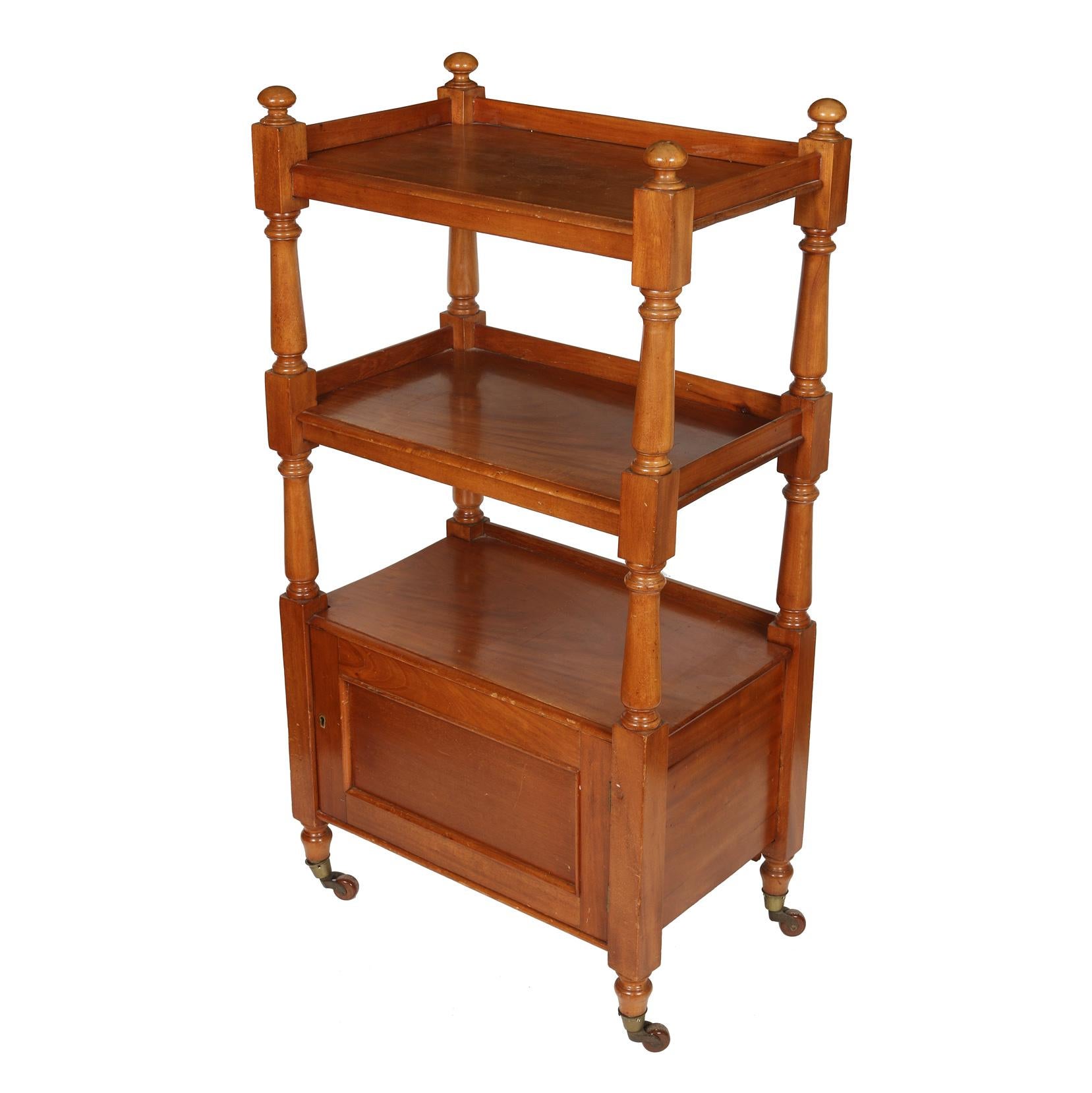 Antique English oak three-tier étagère with four posts and casters. Lower cabinet swings open for storage.