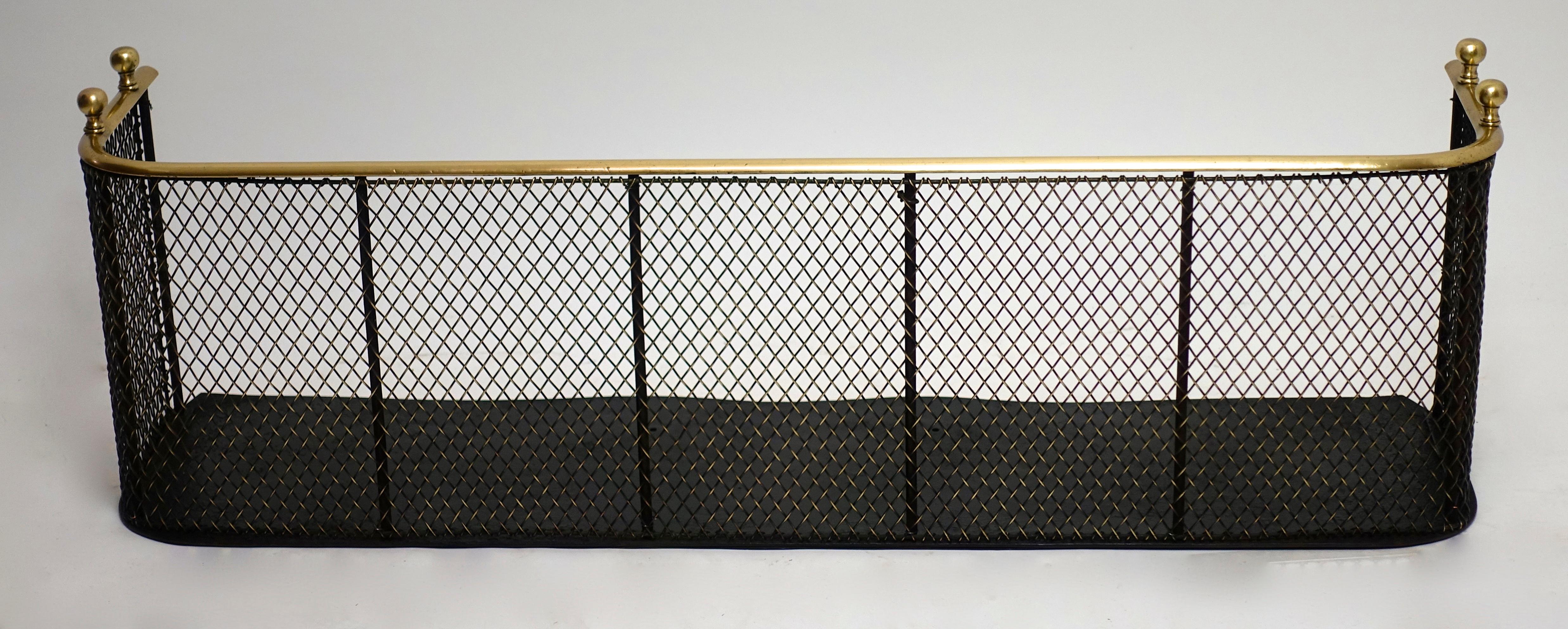 Handsome and useful English or American brass and black painted iron fire fender from the 
early 19th century with four finials with an unusual heavy brass mesh screen in
excellent antique condition.