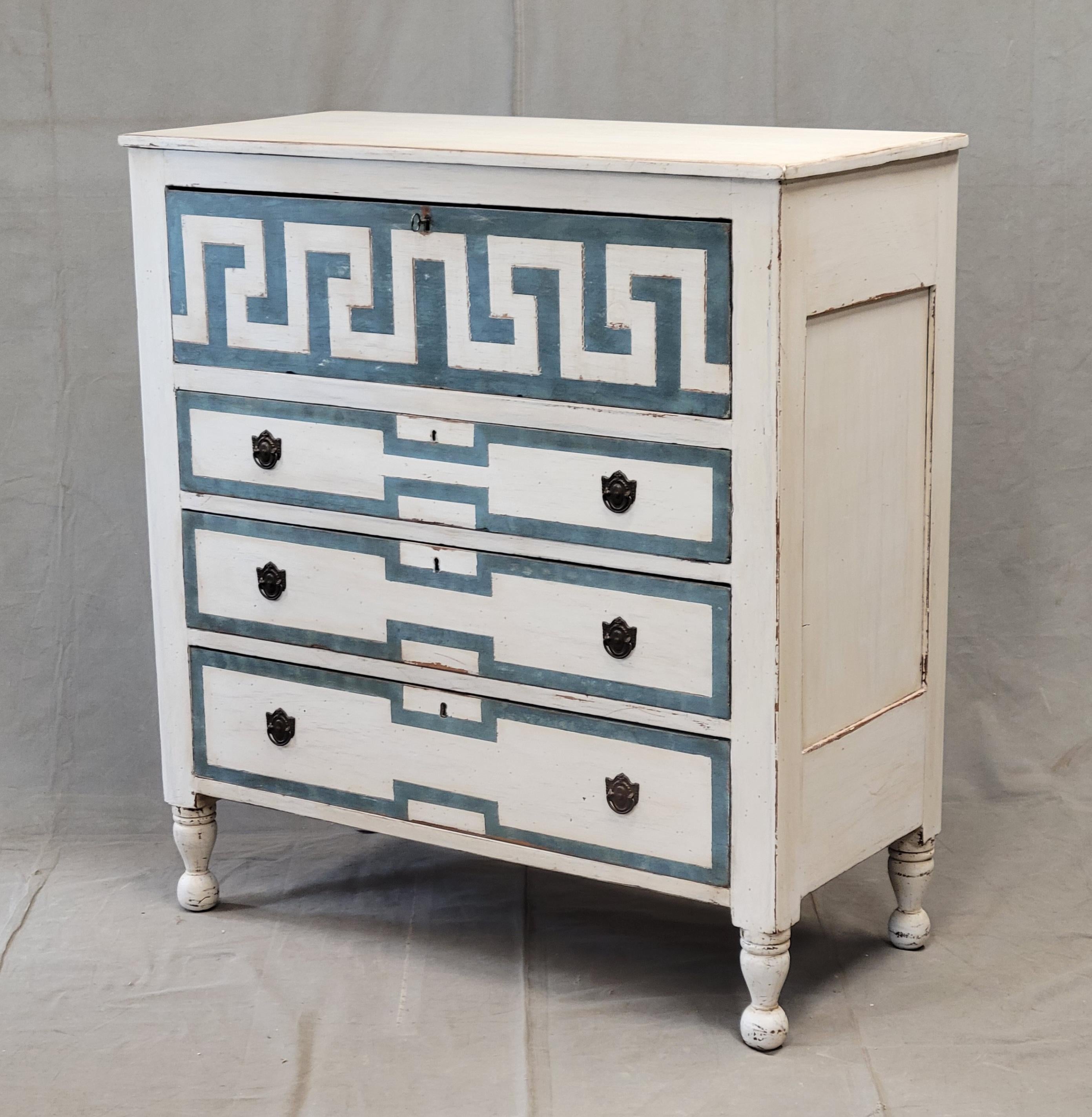 An absolutely stunning antique hand painted dresser with distressed white paint and blue trompe l'oeil French line motif. The top drawer is embellished with a trompe l'oeil Greek key motif. The four drawers glide smoothly and offer plenty of