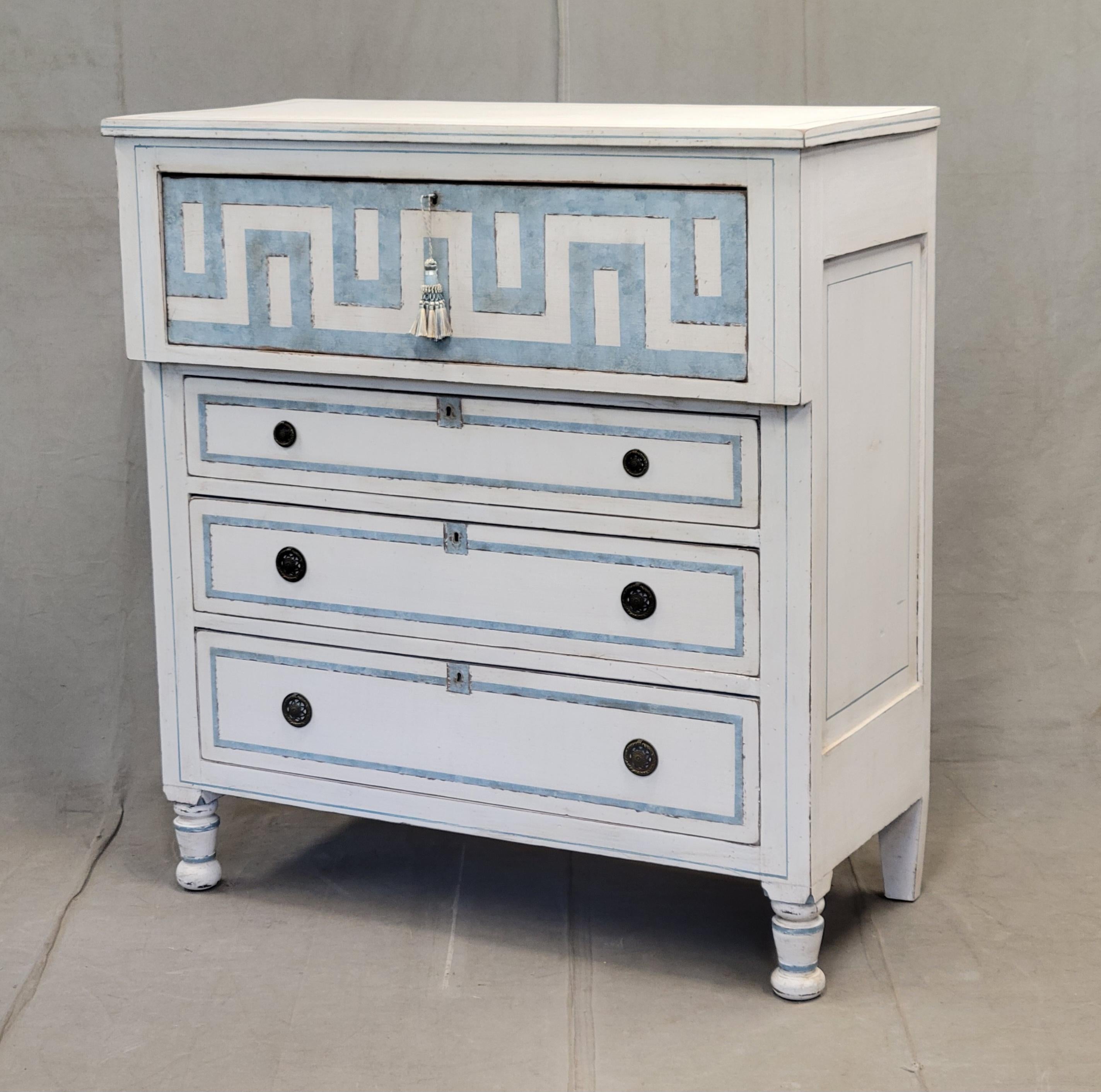 An absolutely stunning antique hand painted dresser with distressed white paint and pale blue trompe l'oeil French line motif. The top drawer is embellished with a trompe l'oeil Greek key motif. The four drawers glide smoothly and offer plenty of