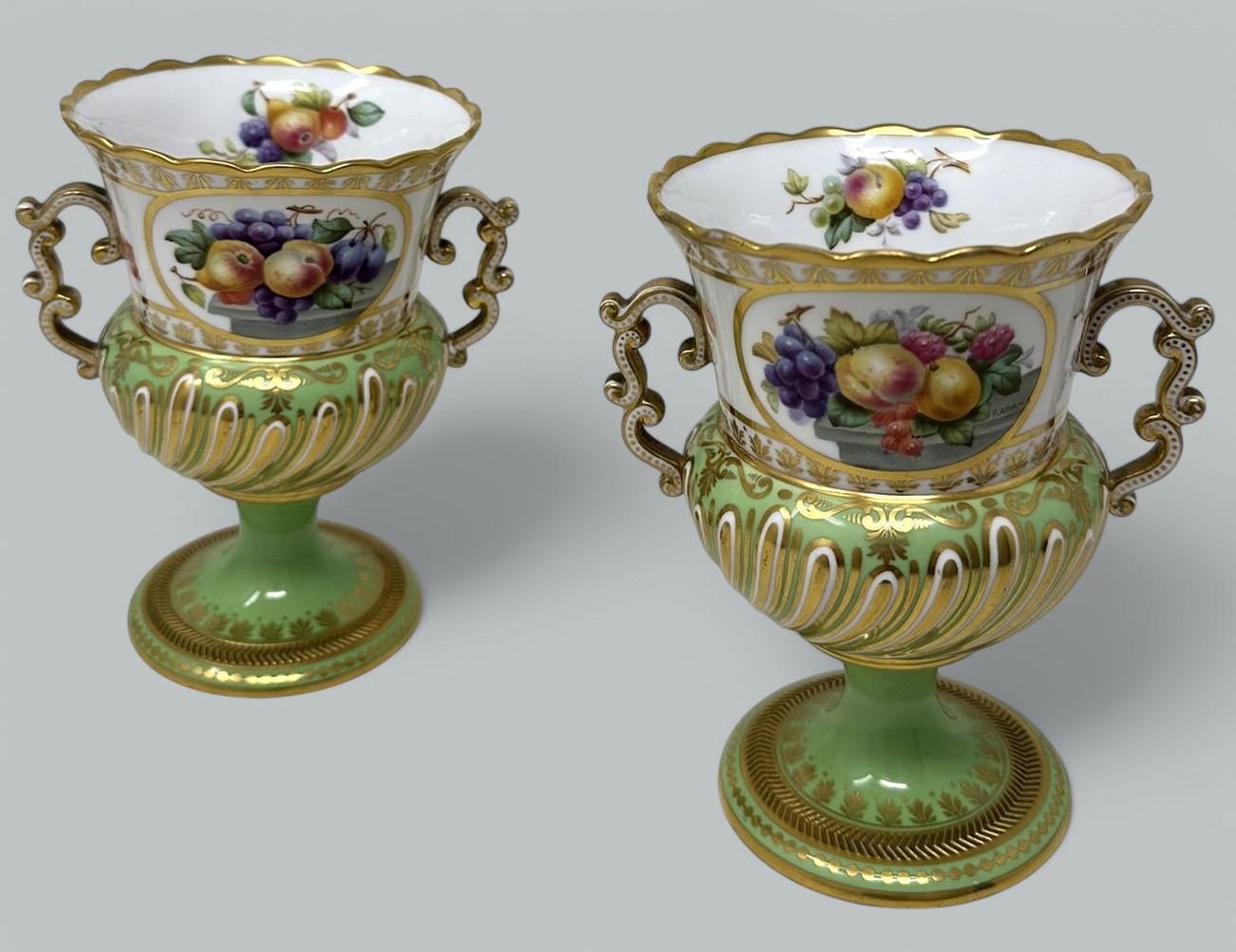 Stunning Pair of English Frederick Adams Copeland Porcelain Hand Painted Two Handled Mantle Vases of Museum quality of campana form, ending on exquisitely decorated raised gilt circular bases. Circa 1895-1905. 

Each central reserve exquisitely hand