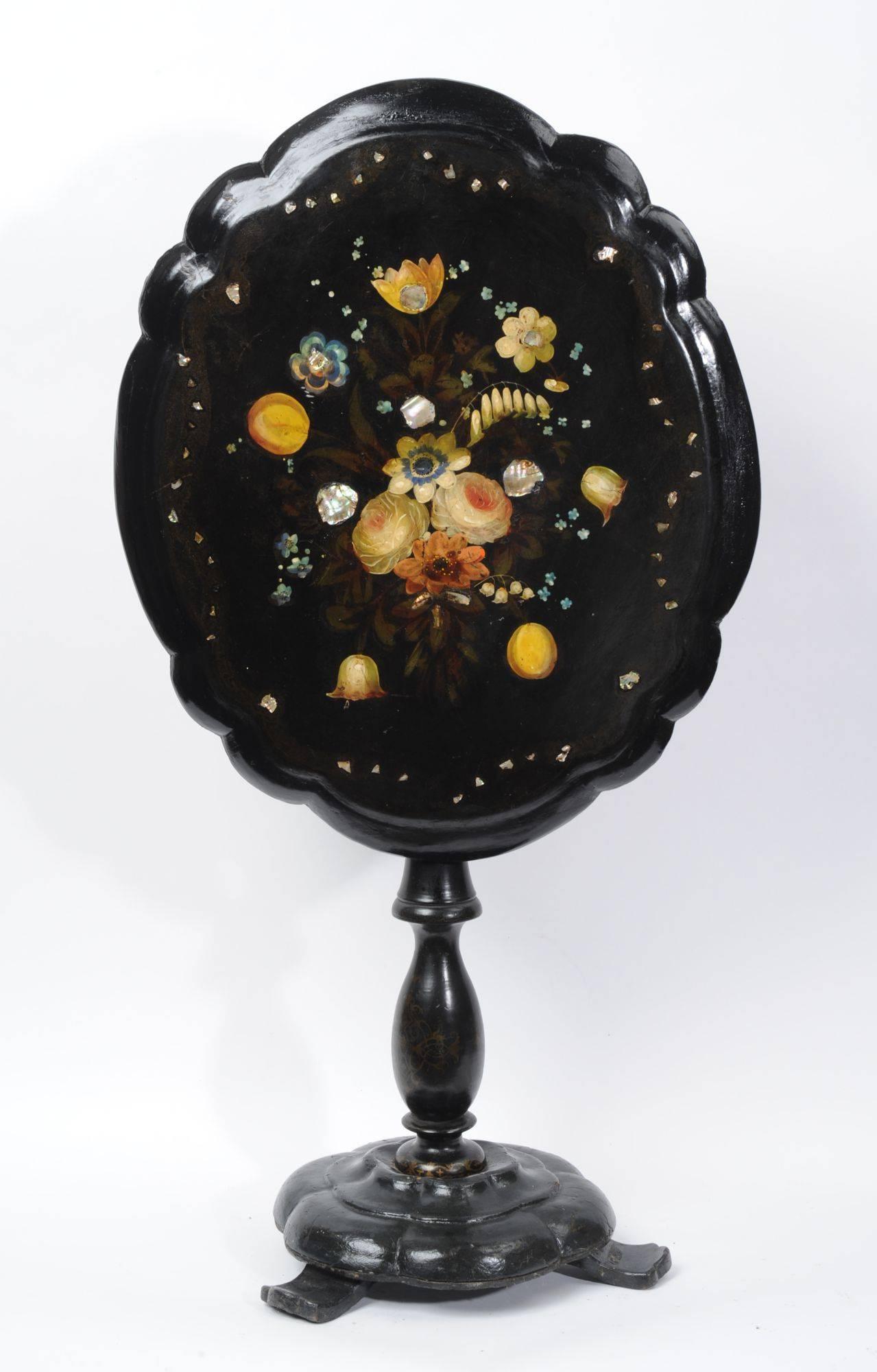 A beautiful Papier-Mache tilt top occasional table, hand-painted with flowers and inlaid with mother-of-pearl. Gilt decoration has faded gently with age.