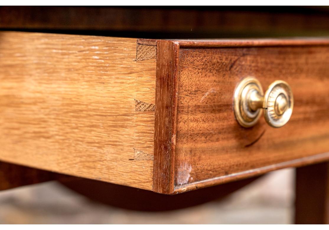 Une table de jeu anglaise ancienne de bonne facture et de bonne taille, avec des bandes et un tiroir unique construit en queue d'aronde. La partie supérieure centrale coulisse pour révéler un plateau de backgammon incrusté en bois satiné et en