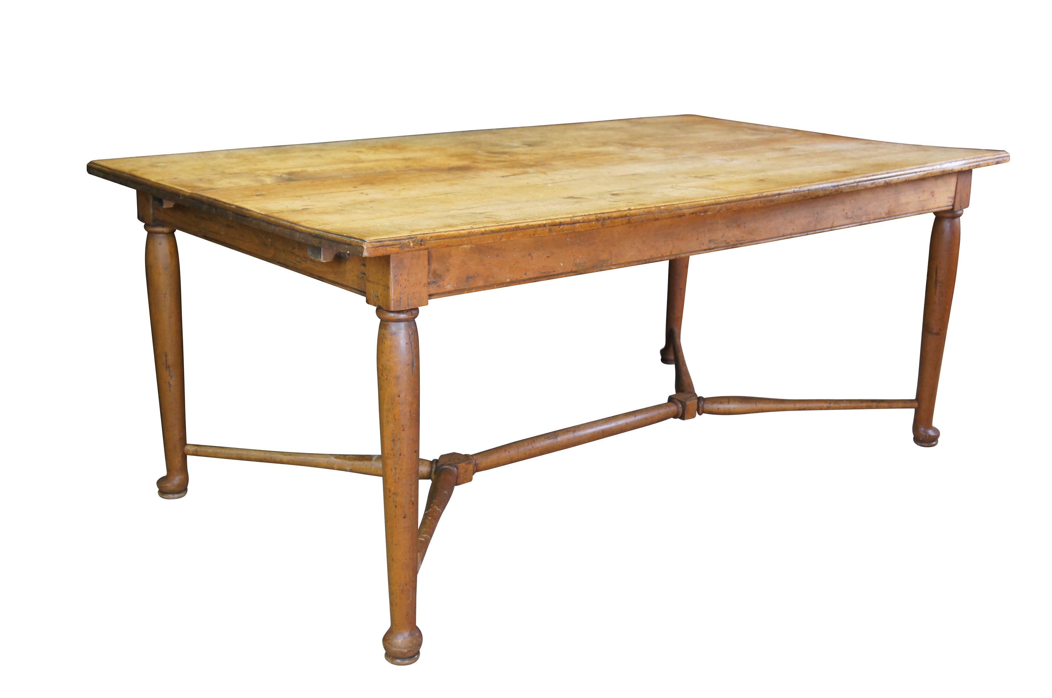 Antique primitive English farmhouse dining / library table. Made of pine featuring a plank top with slipper feet connected by trestle base stretcher. The table was originally a draw leaf table before being used in a library as a
