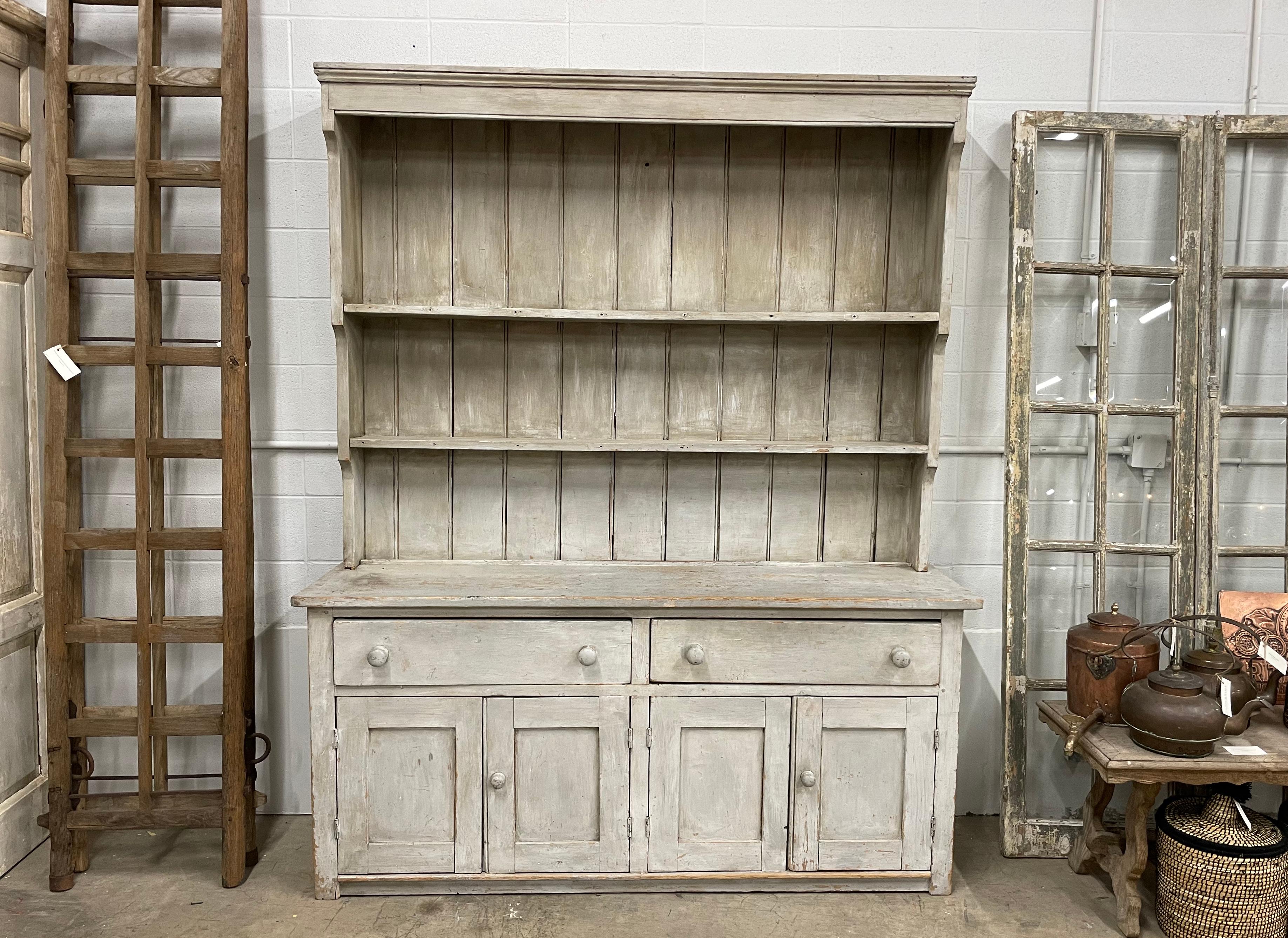 Antique English pine potboard dresser with old paint. It has plenty of storage with 2 double cupboard doors below 2 drawers. Lovely old wooden pulls typical of the period.

This is a very simple farmhouse design that works well in both period and