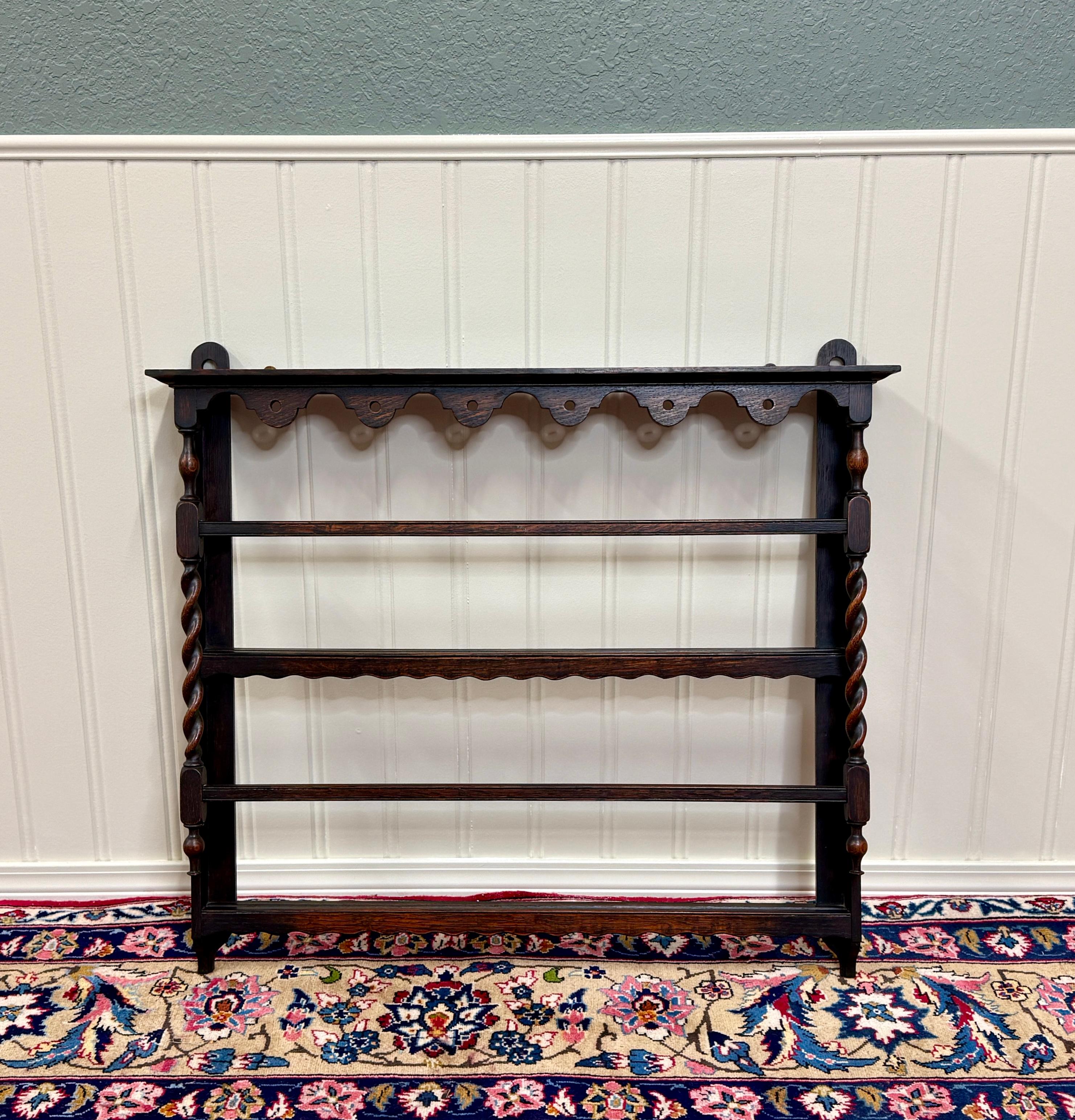 CHARMING Antique English Carved Oak Plate Rack~~ Barley Twist Posts and Drop Finials~~c. 1920s
 
Popular classic English hanging wall plate rack~~barley twist posts~~plate grooves and hangers on back~~perfect for an entry hall, kitchen, living area,