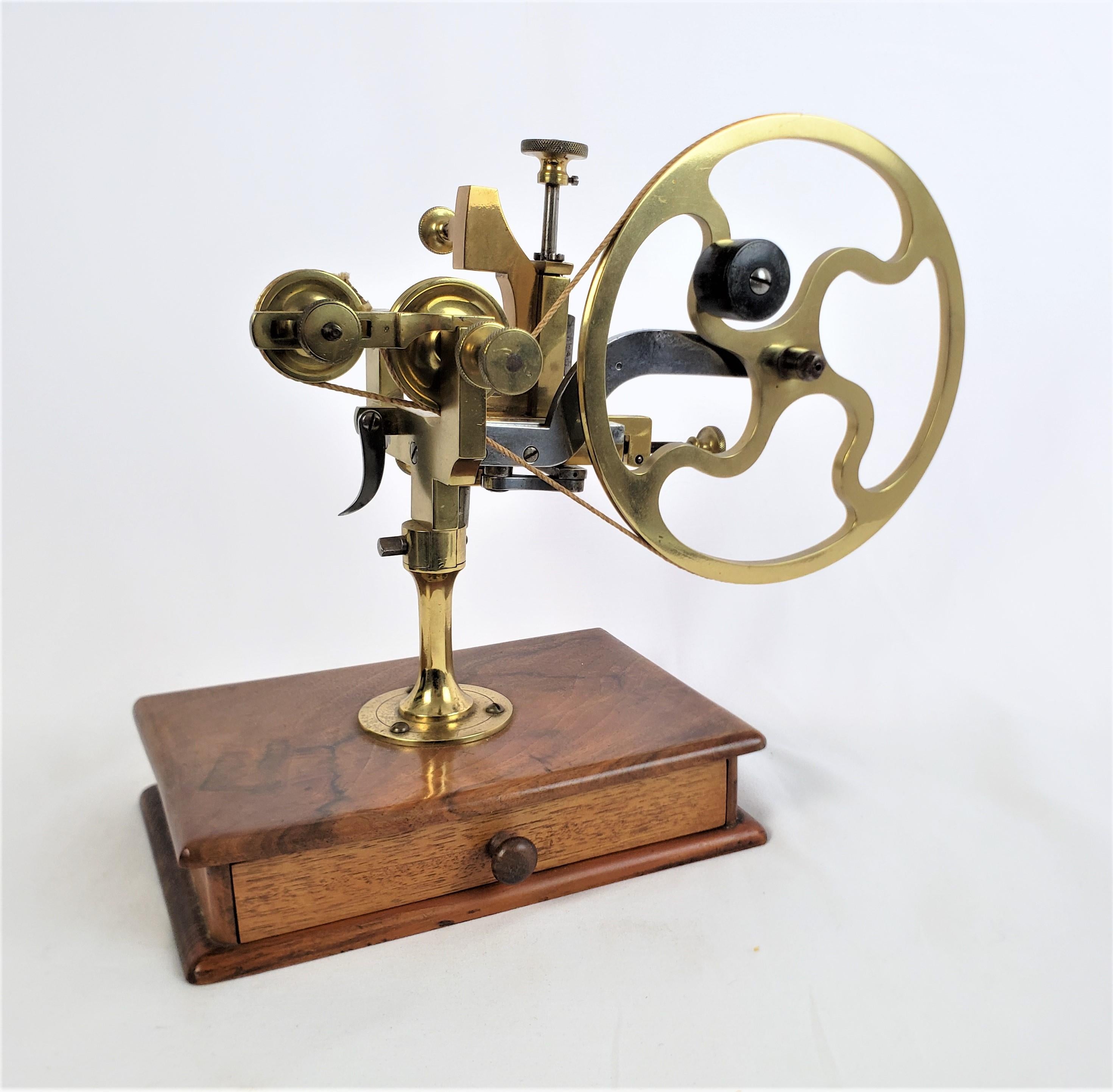 This antique watchmakers lathe is unsigned, but presumed to have originated from England and date to approximately 1880 and done in the period Late Victorian style. The lathe is composed of polished brass and the stand is made of solid wood with a