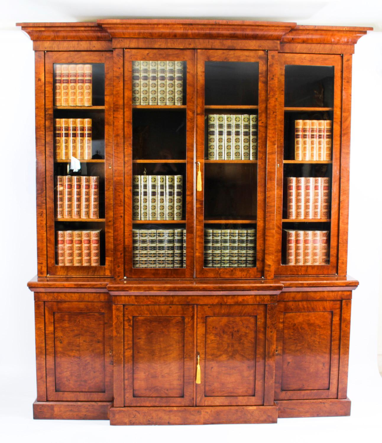 This is a beautiful and rare antique English George IV Pollard oak four door library breakfront bookcase, circa 1830 in date.

This magnificent bookcase features four glazed doors in the upper section revealing the twelve original oak shelves that