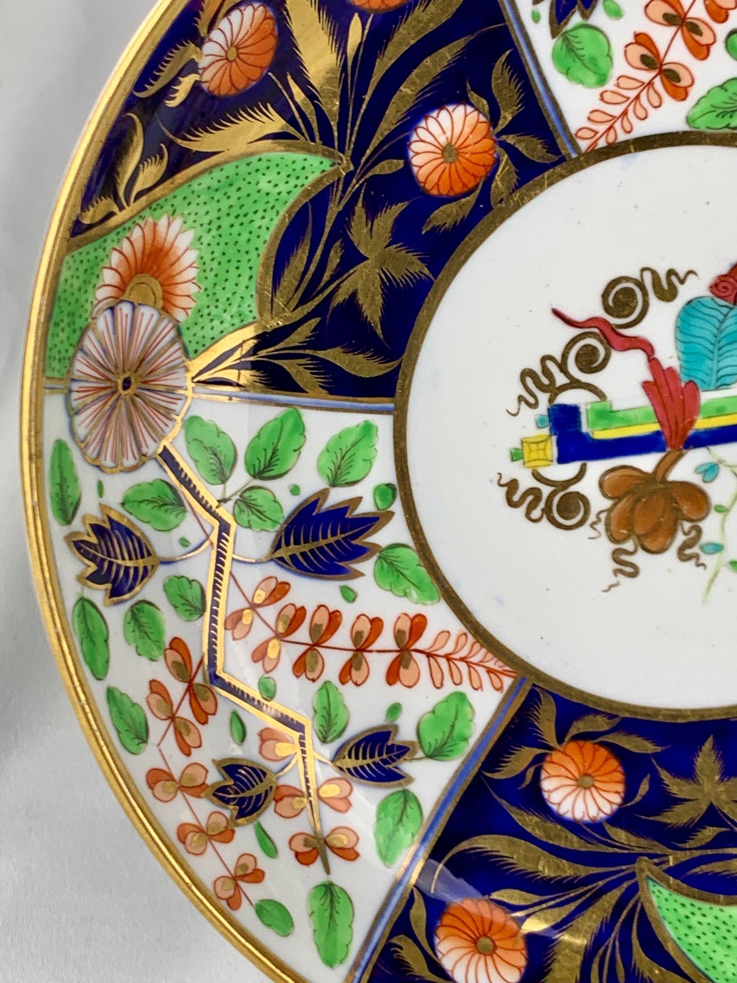 Questo antico piatto di porcellana è stato dipinto a mano da Spode a Stoke-upon-Trent, in Inghilterra, intorno al 1820. 
Il design presenta una versione raffinata dello stile Imari inglese, evidenziato da un vivace motivo centrale di due volute