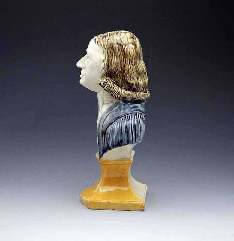 Prattware underglaze pottery bust of the Reverend John Wesley, one of the founders of the Methodist movement. The famous preacher is dressed with a dark blue gown and is mounted onto a waisted yellow ochre socle base.

Dimensions: 3.75 inch wide