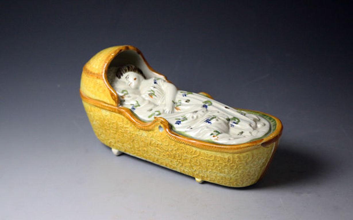 Antique English Pottery Figure of a Child in a Cradle, Early 19th Century In Good Condition For Sale In Woodstock, OXFORDSHIRE