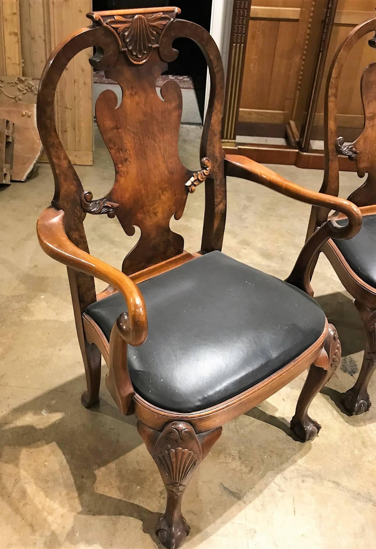 Superior set of eight antique English Queen Anne style walnut dining chairs with shell carved crests, balloon backs, and spooned splats. The front legs of cabriole form having shell carved knees ending in ball and claw feet. Each with slip seats.