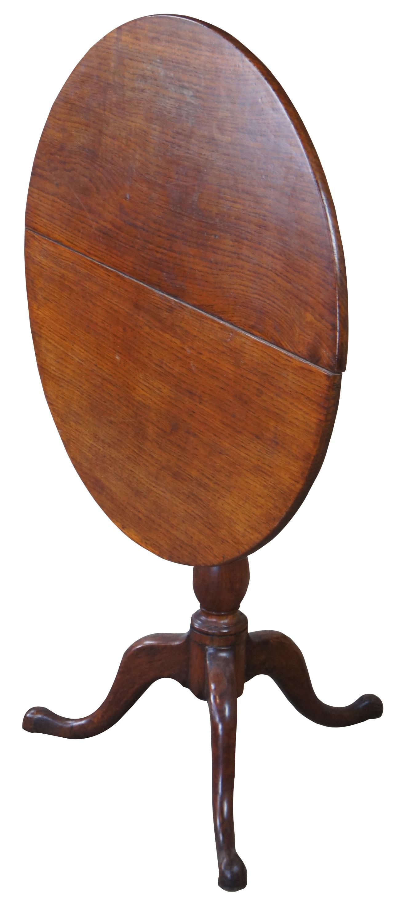 Late 19th century Queen Anne style tilt top table. Made from pine with a round top supported by a turned baluster over cabriole legs leading to pad feet. Latch along underside.
  