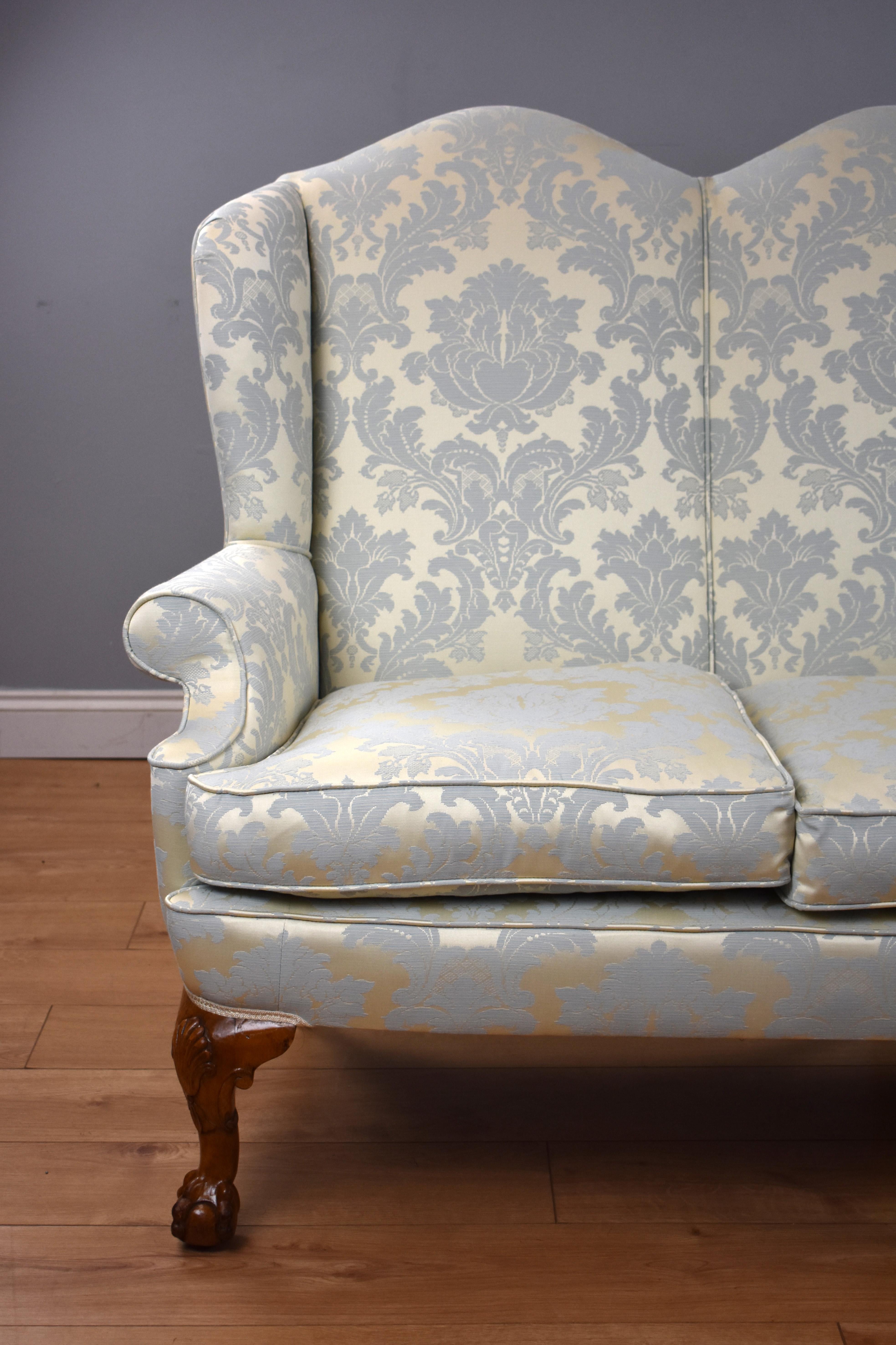 For sale is an antique Queen Anne style three-seat sofa, having arched backs, with scroll arms, standing on elegant carved cabriole legs, the sofa remains in very good condition. The settee is upholstered with a medallion pattern in damask.