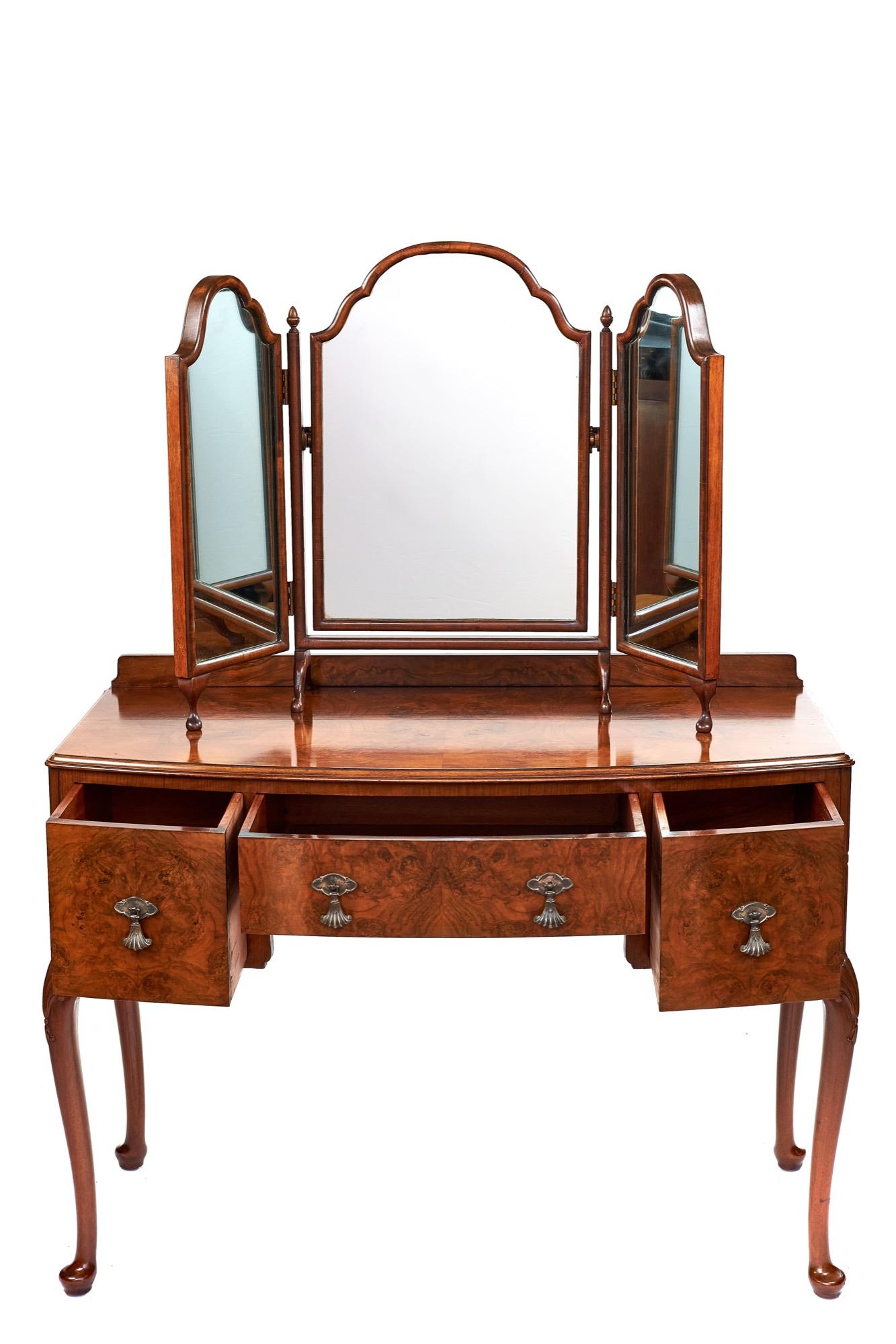Antique English Queen Anne style walnut bow front kneehole dressing table having a walnut framed free standing triptych mirror. A beautiful figured walnut top with a three drawer kneehole base. The drawers all have the original fan shaped drop