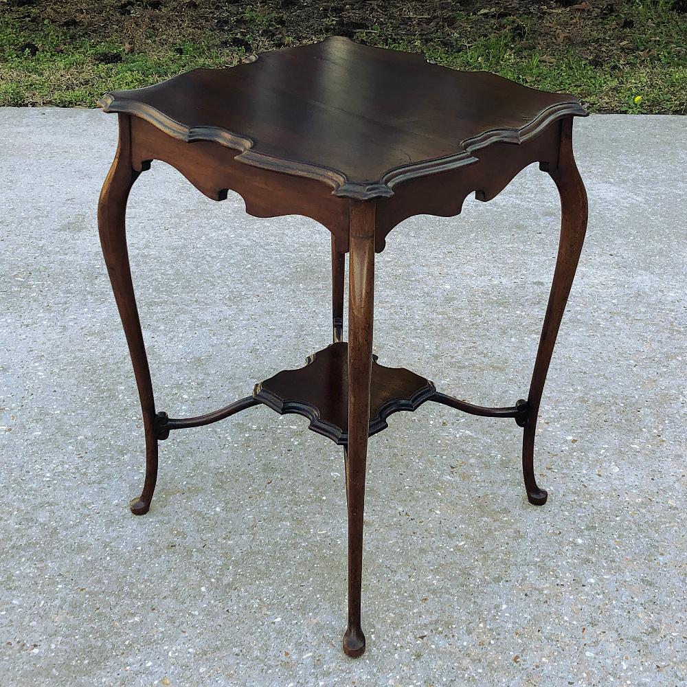 Antique English Queen Anne walnut end table features an elegant design with gracefully scrolled legs, club feet, a beautifully contoured apron with beveled top that follows the contours of that apron, and a lower center shelf supported and uplifted