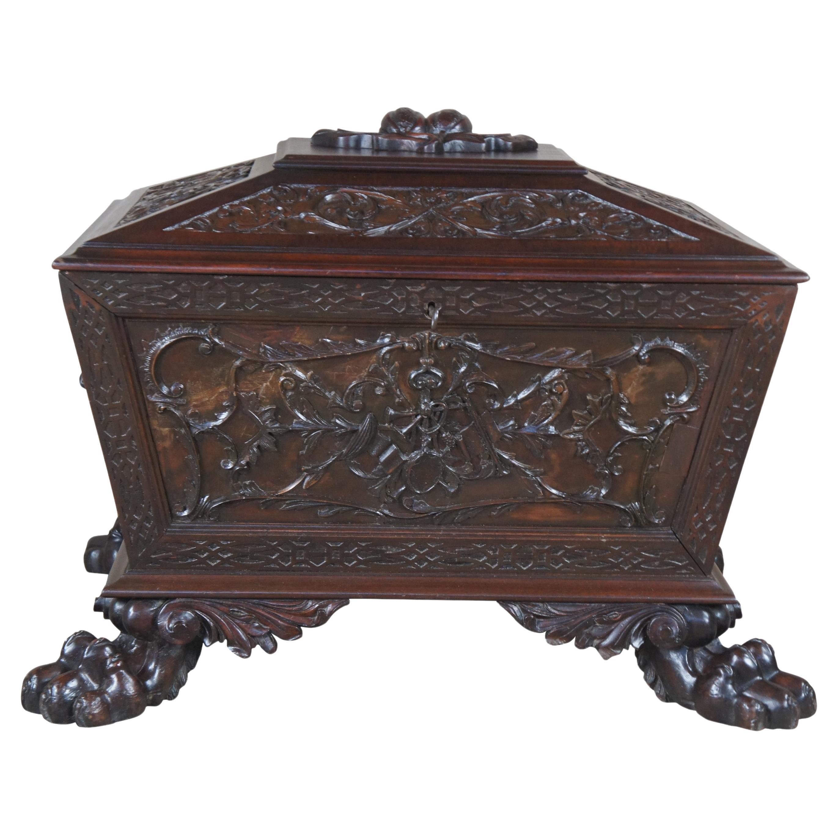 
Antique English Regency cellarette / cassone casket / coffer / coffret , trunk or marriage chest. Made of carved mahogany featuring blind fretwork with Neoclassical floral and acanthus designs, fruit and berries, high relief carved lion heads and