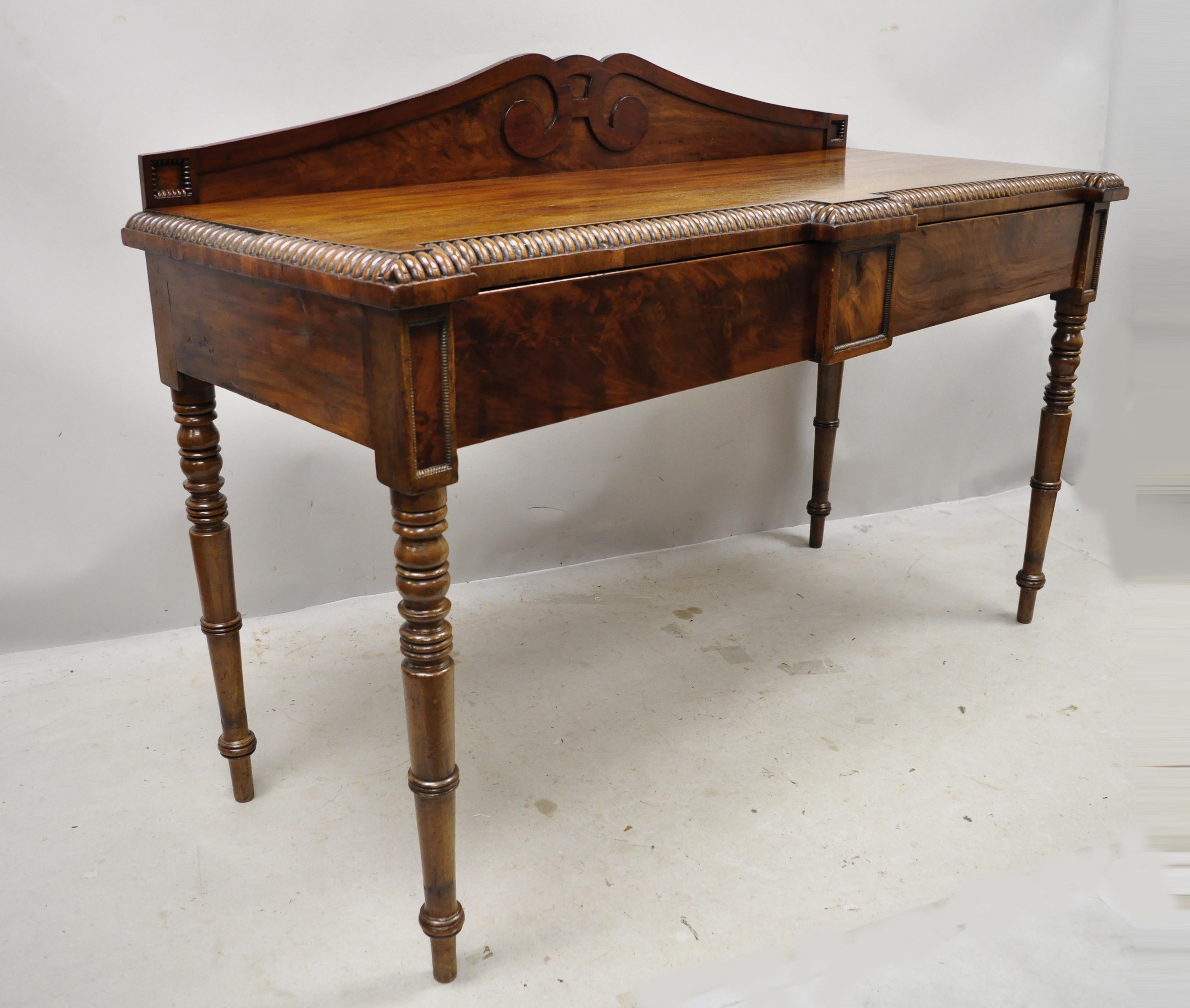 19th century antique English Regency crotch mahogany rope carved sideboard console table with backsplash. Item features 2 drawers, turn carved legs, rope carved edge, carved backsplash, solid wood construction, beautiful wood grain, very nice