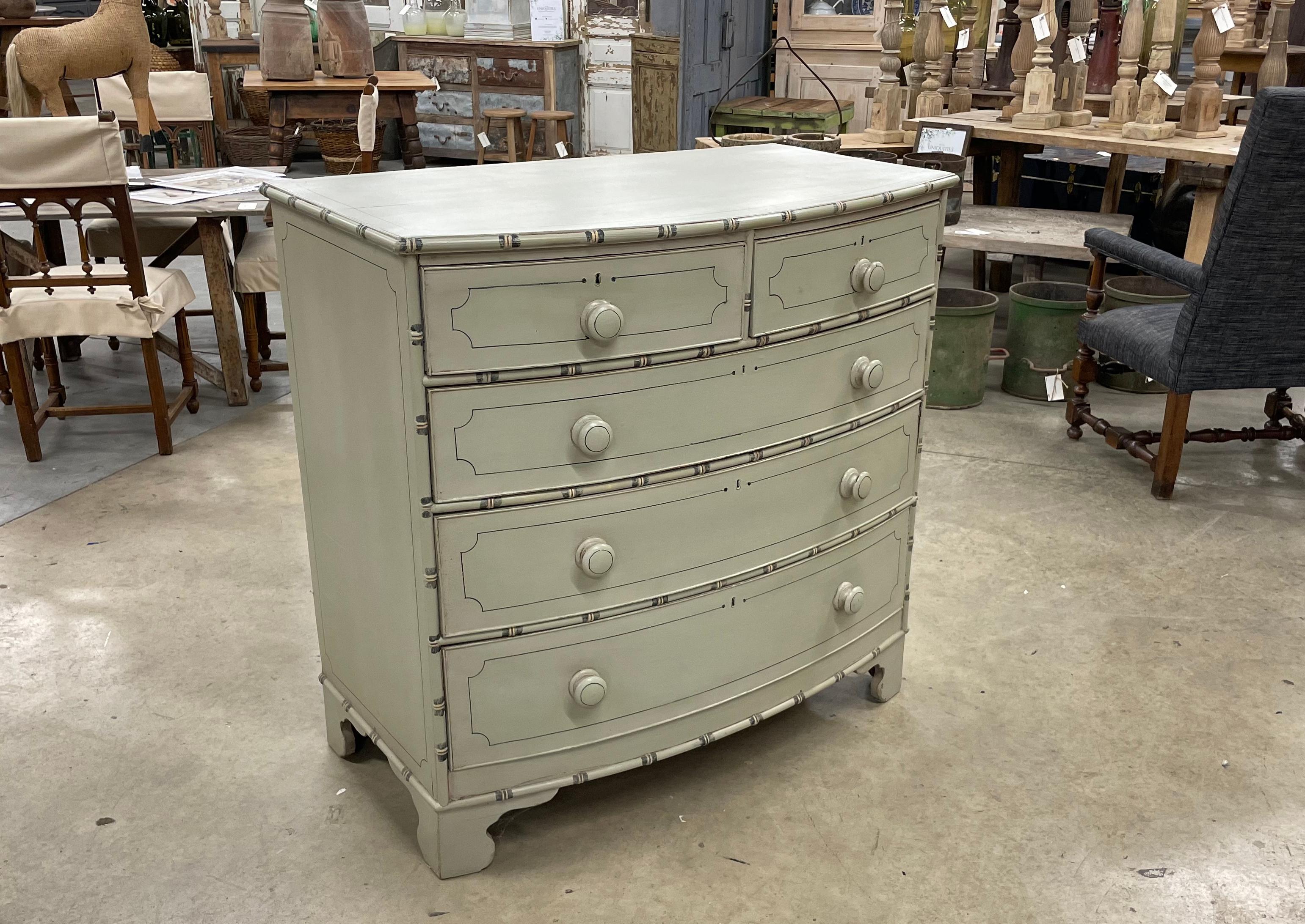 Antique English Regency bow fronted chest of drawers.

This beautiful painted faux bamboo dresser has 2 smaller drawers over 3 larger drawers with original wooden knobs and sits on stile feet.

A versatile piece of furniture that does not have to be