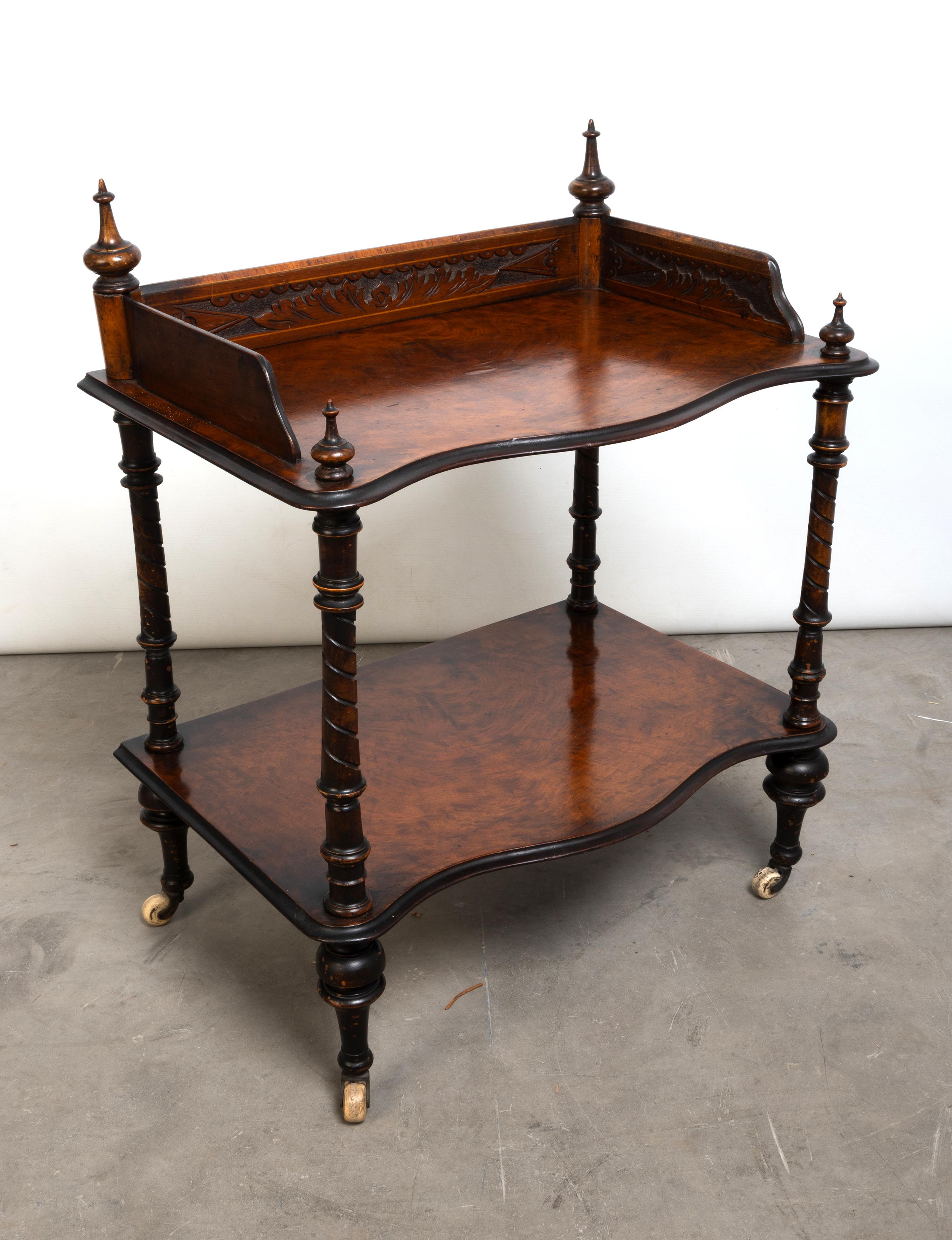 Antiguo expositor/estantería de nogal figurado inglés de la Regencia C.1820

Tribuna tallada con remates torneados en la parte superior, soportes verticales torneados, sobre elegantes pies torneados con ruedas de porcelana blanca.  
Una pieza de