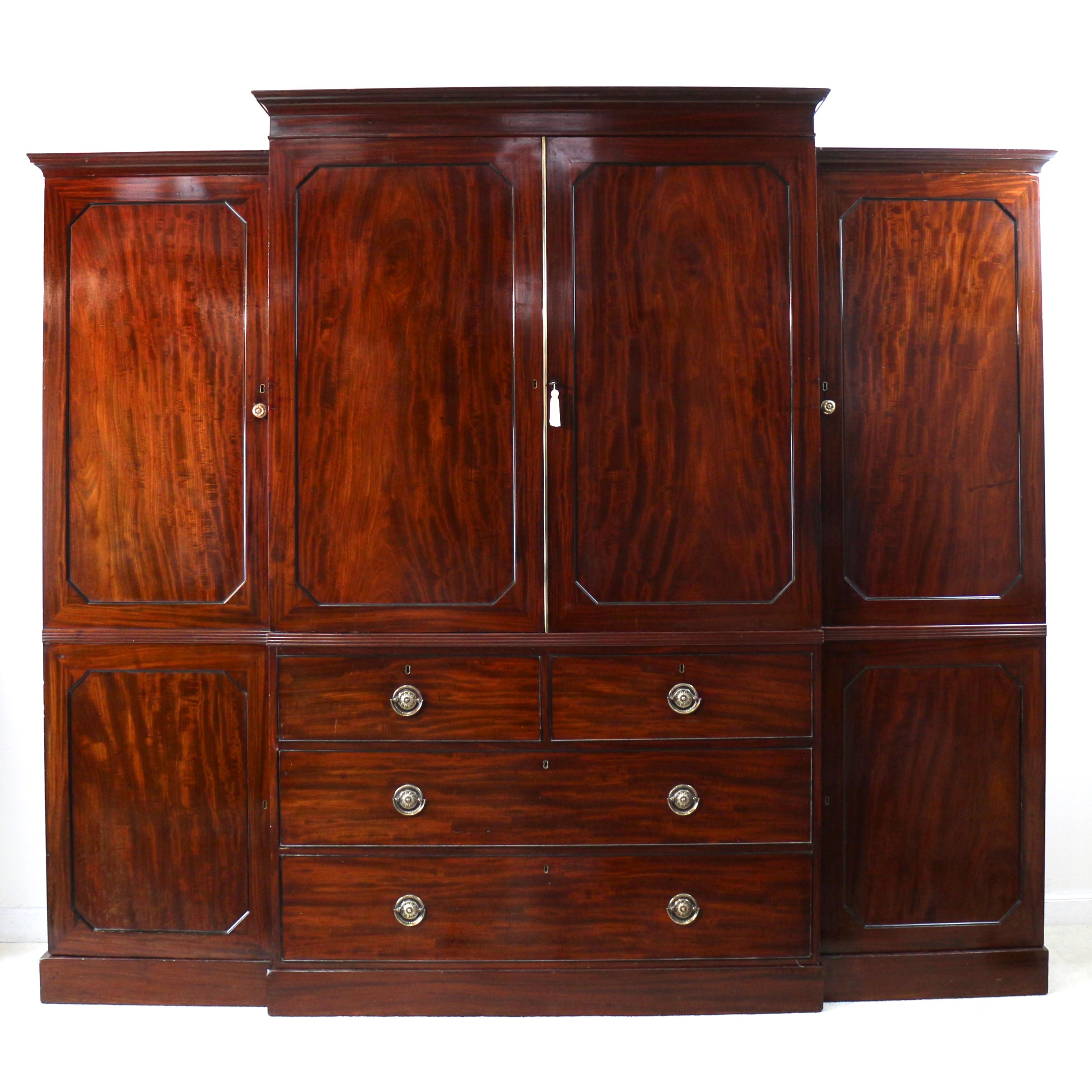 A superb quality and impressive Regency breakfront flame mahogany gentleman’s linen press wardrobe dating to circa 1820 and attributable to Gillows of Lancaster. Featuring a stepped moulded cornice above a pair of projecting fielded panelled