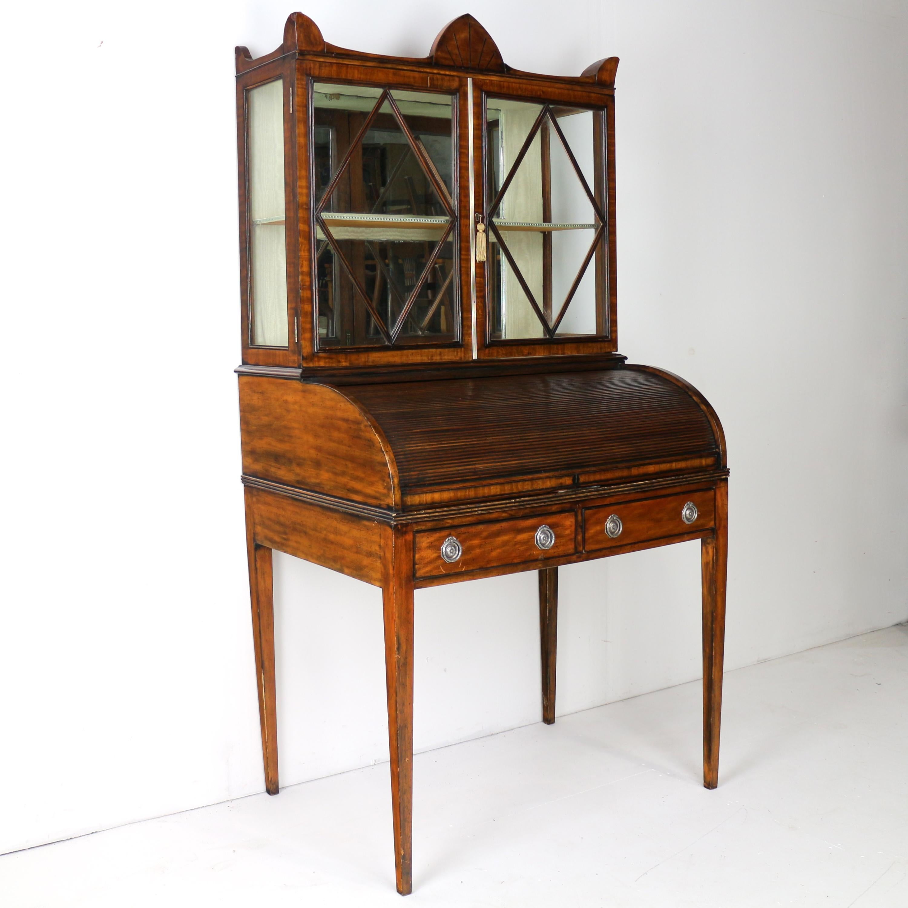 Ein attraktiver Regency-Schreibtischschrank aus Mahagoni und Satinholz für Damen, datiert auf ca. 1815.  Das rechteckige Gesims wird von einem eingelegten Demi-Navette-Giebel über einem Paar verglasten Astragal-Türen mit Rautenmuster und verglasten