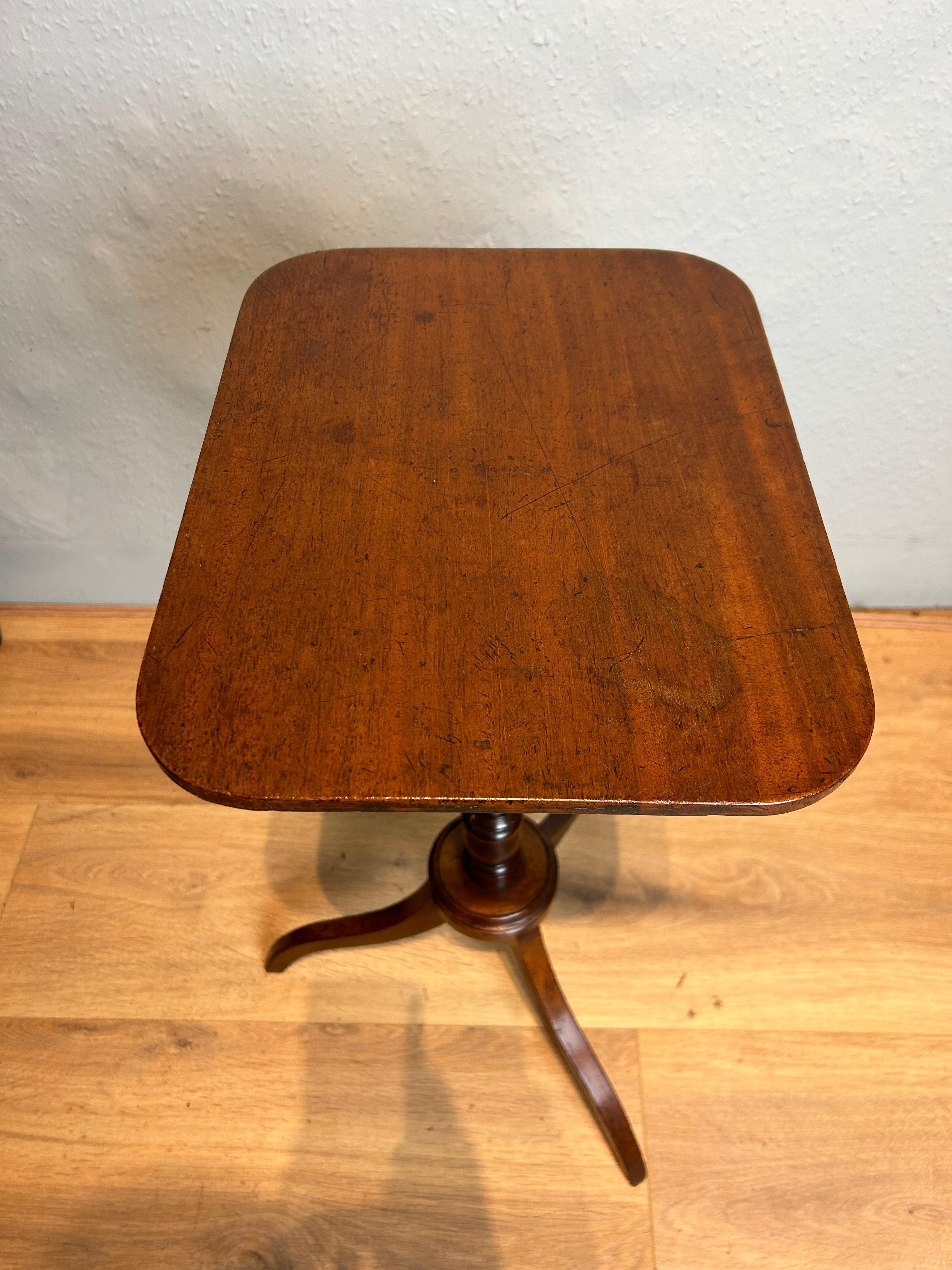 Antique English Regency mahogany lamp/ wine table with a fine thin top on a elegant turned column, resting on a turned moulded collar finishing on umbrella legs