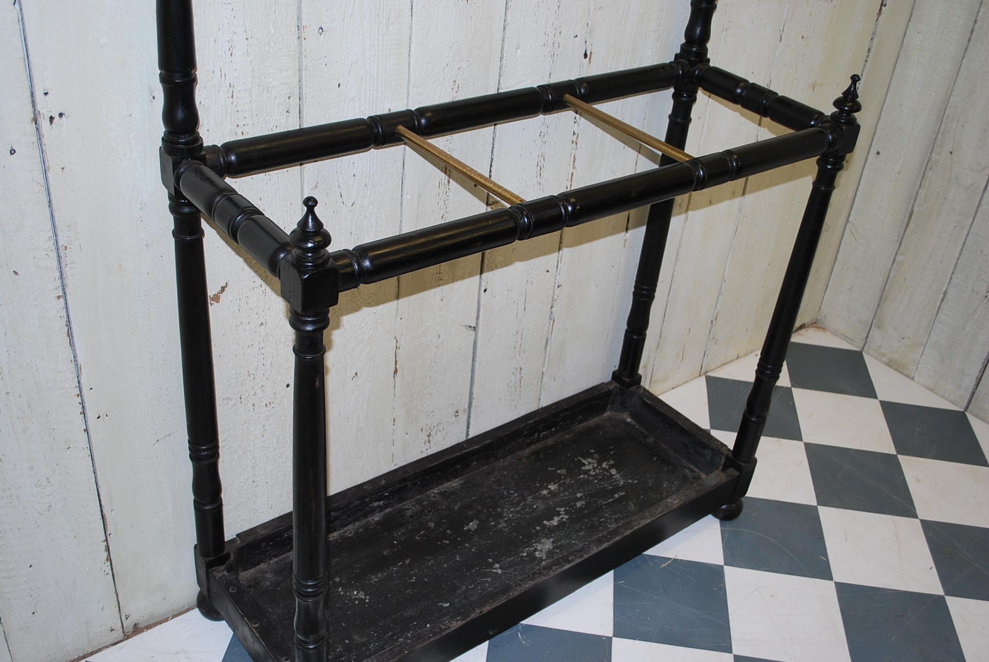 Good quality Regency ebonized hall stand with a tray at bellow with dividers for sticks and hat hooks above.