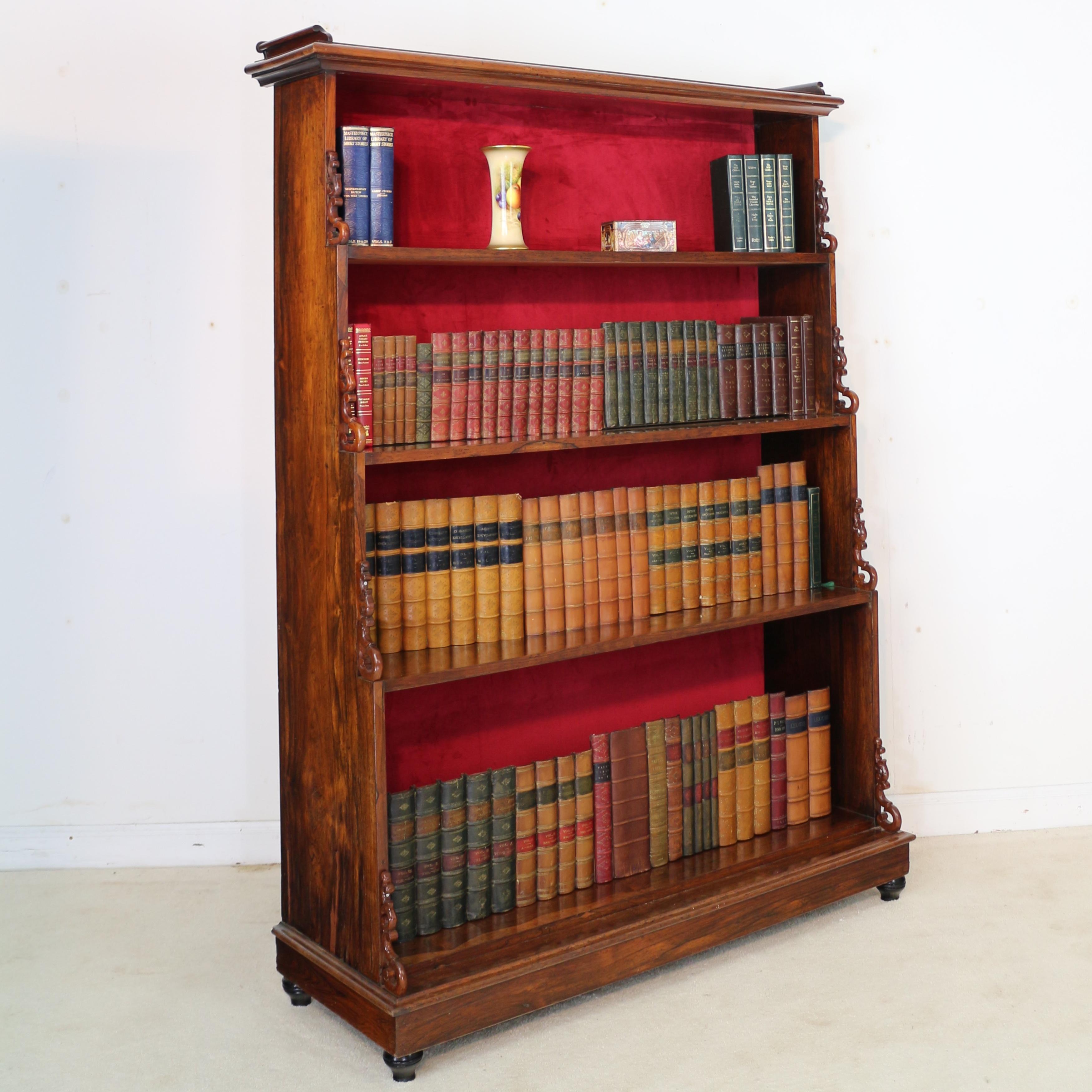 A fine quality Regency rosewood waterfall bookcase dating to circa 1820. The rectangular top with a scrolled gallery over four graduated shelves with scrolling pierced mounts, on a plinth base with four turned ebonized feet. The paneled back covered