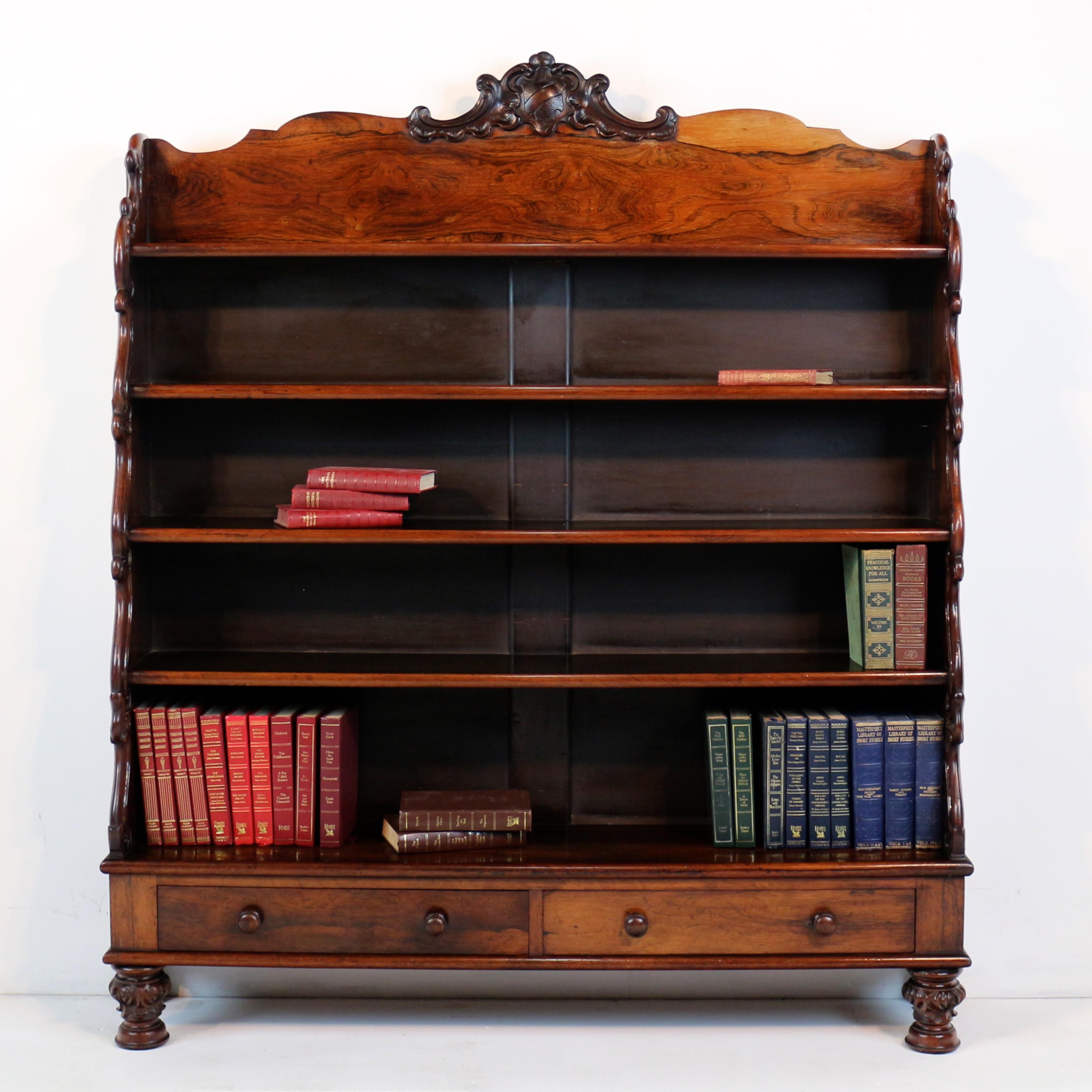 Furnish your home with timeless elegance – introducing our antique Regency rosewood waterfall bookcase, made in England circa 1820. Crafted with exquisite attention to detail, this piece seamlessly blends curving acanthus leaves with a carved shield