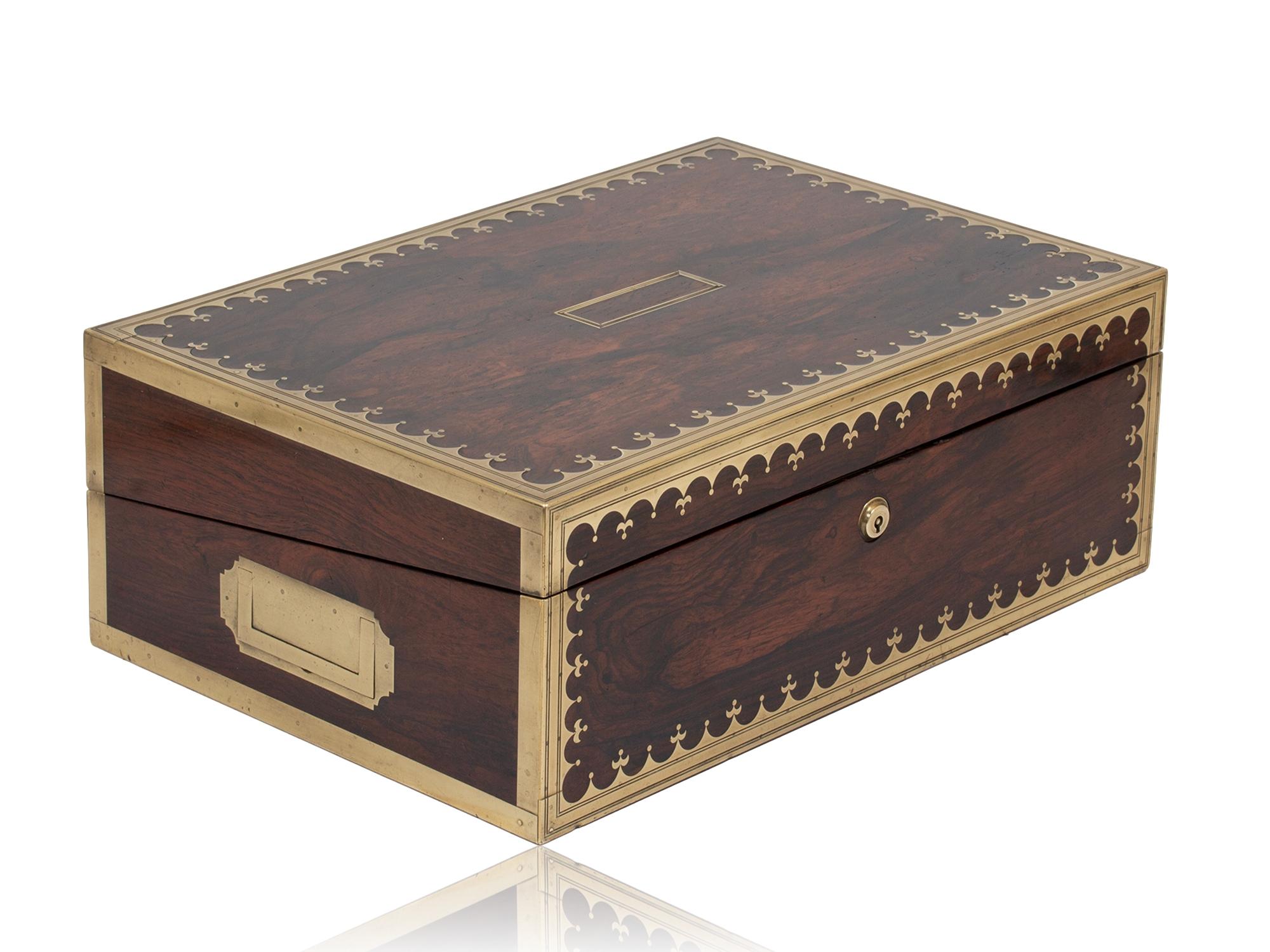 Hidden Secret Compartment

From our Writing Box collection, we are pleased to offer this Regency Rosewood Writing Box by David Edwards. The Writing Box veneered in Rosewood with extensive brass inlay with a double parallel engraving to the front and
