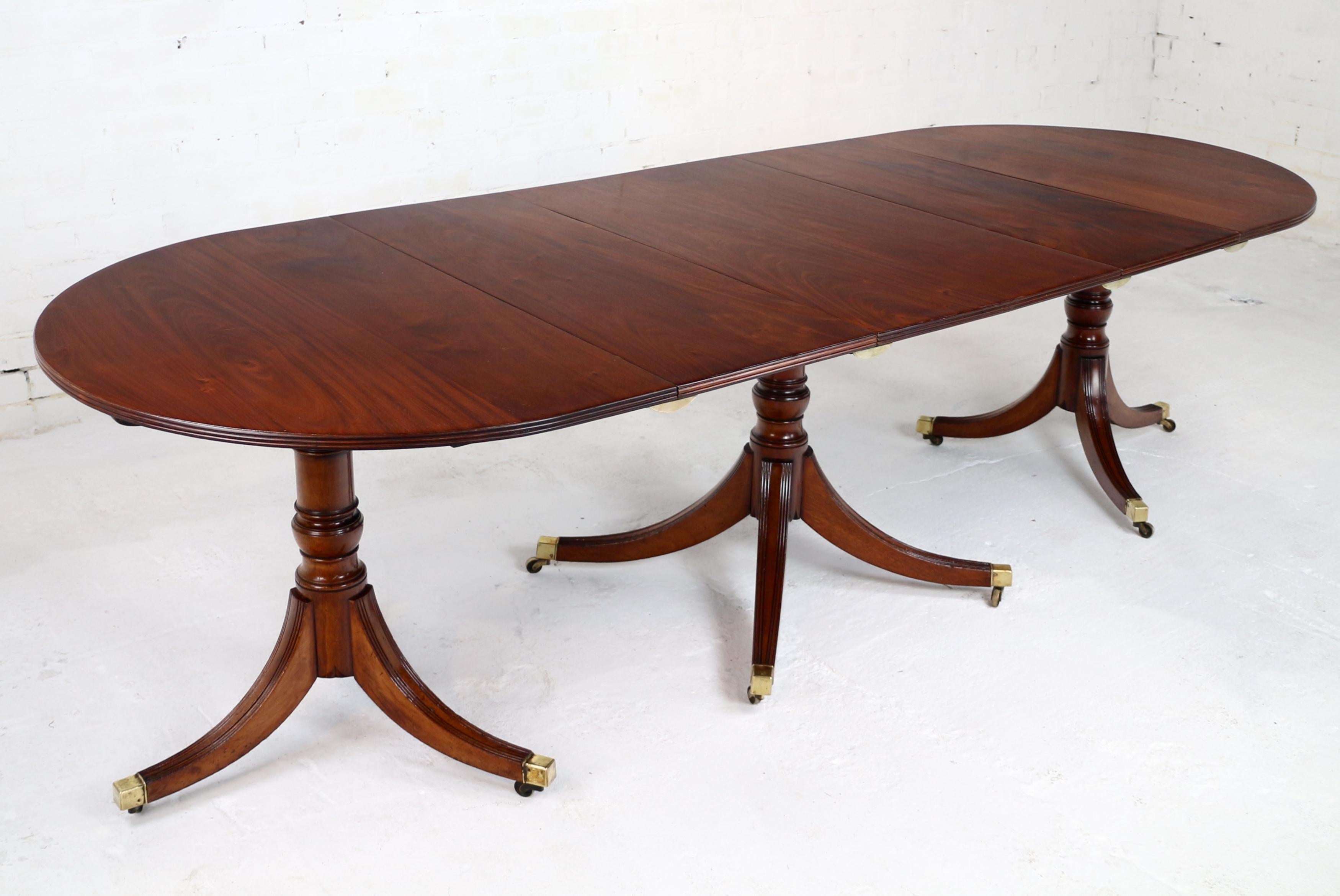 An elegant and well proportioned Regency period English mahogany triple pedestal dining table, constructed from well figured solid mahogany this handsome table comprises two D-shaped ends, centre section and two extension leaves which provide