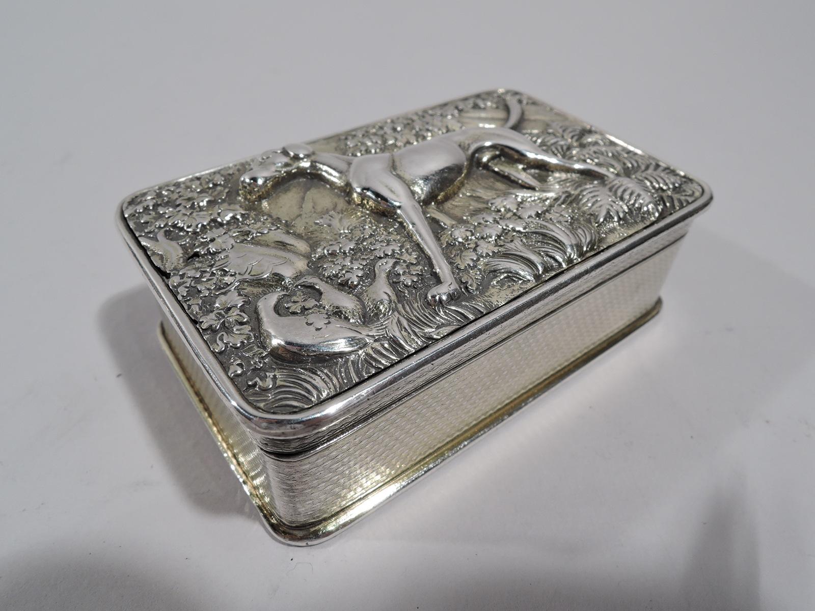 George III English sterling silver snuffbox, 1819. Rectangular with straight engine-turned sides and curved corners; underside also engine-turned. Cover hinged with low-relief hound standing alert amidst verdure, a few gamebirds tucked away in a
