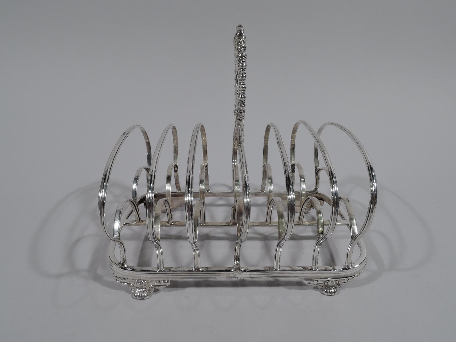 Regency sterling silver toast rack. Made by Benjamin Prestion in London in 1829. Curved and reeded rectangular frame with central stretcher, supporting 7 partitions double arches set in large shaped single arch. Leaf-mounted ring finial with