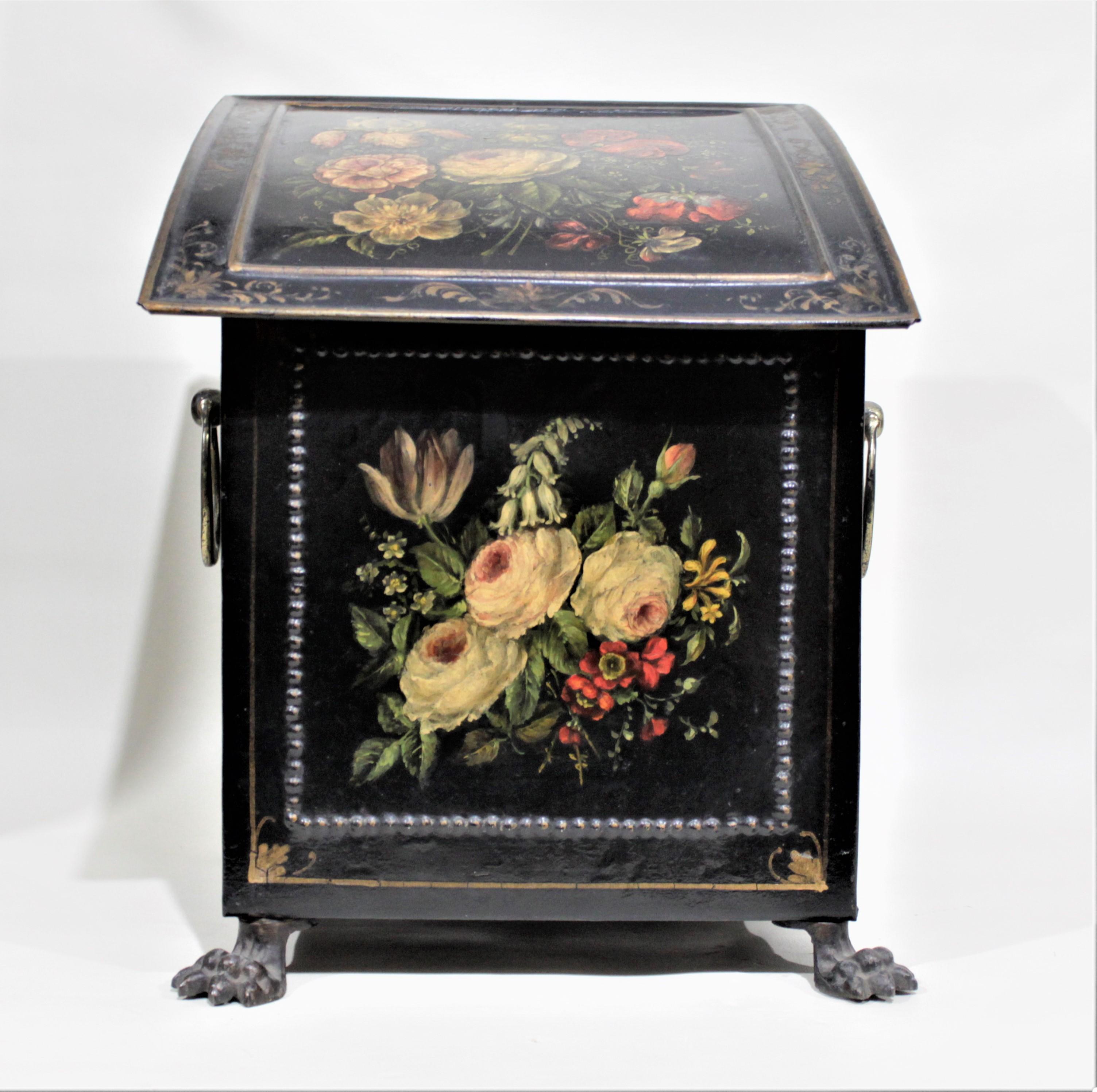 This antique metal coal box or coal scuttle is presumably made in England during the 1820s in the Regency period and style. The box is constructed of thin metal sheeting, with a convex hinged top and claw feet. The entire box is painted in a glossy