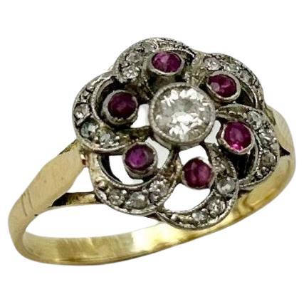 Antiquarian English filigree gold ring with diamonds and rubies from the early 20th century.

A beautiful, delicate composition with a centrally placed old-cut diamond weighing 0.16 ct, surrounded by six rubies and rays of eighteen smaller