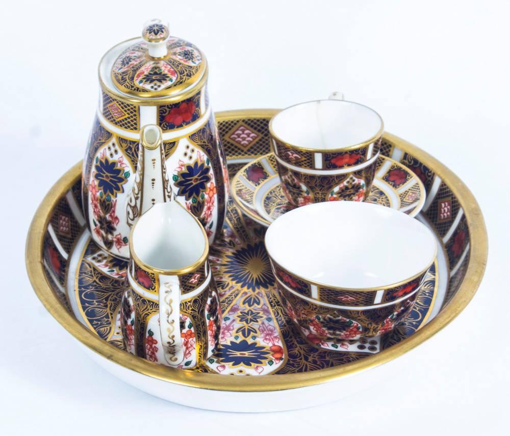 This is a wonderful antique late Victorian English Royal Crown Derby miniature tea set, decorated in the stunning Imari palette with gilded highlights, late 19th century in date and bearing the red 1128 crown mark.

It comprises an oval teapot, a