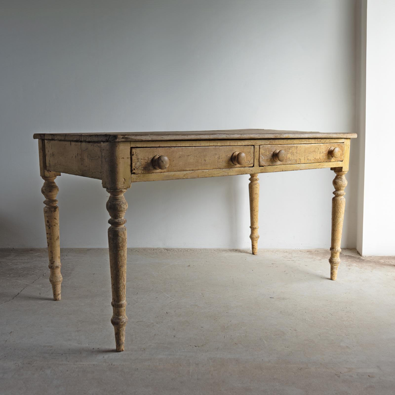 ANTIQUE TABLE

A decorative and rustic piece constructed of pine with turned legs and two frieze drawers with original turned wooden handles. 

The base has remnants of the original buttery, creamy yellow paint, which has worn naturally over time to