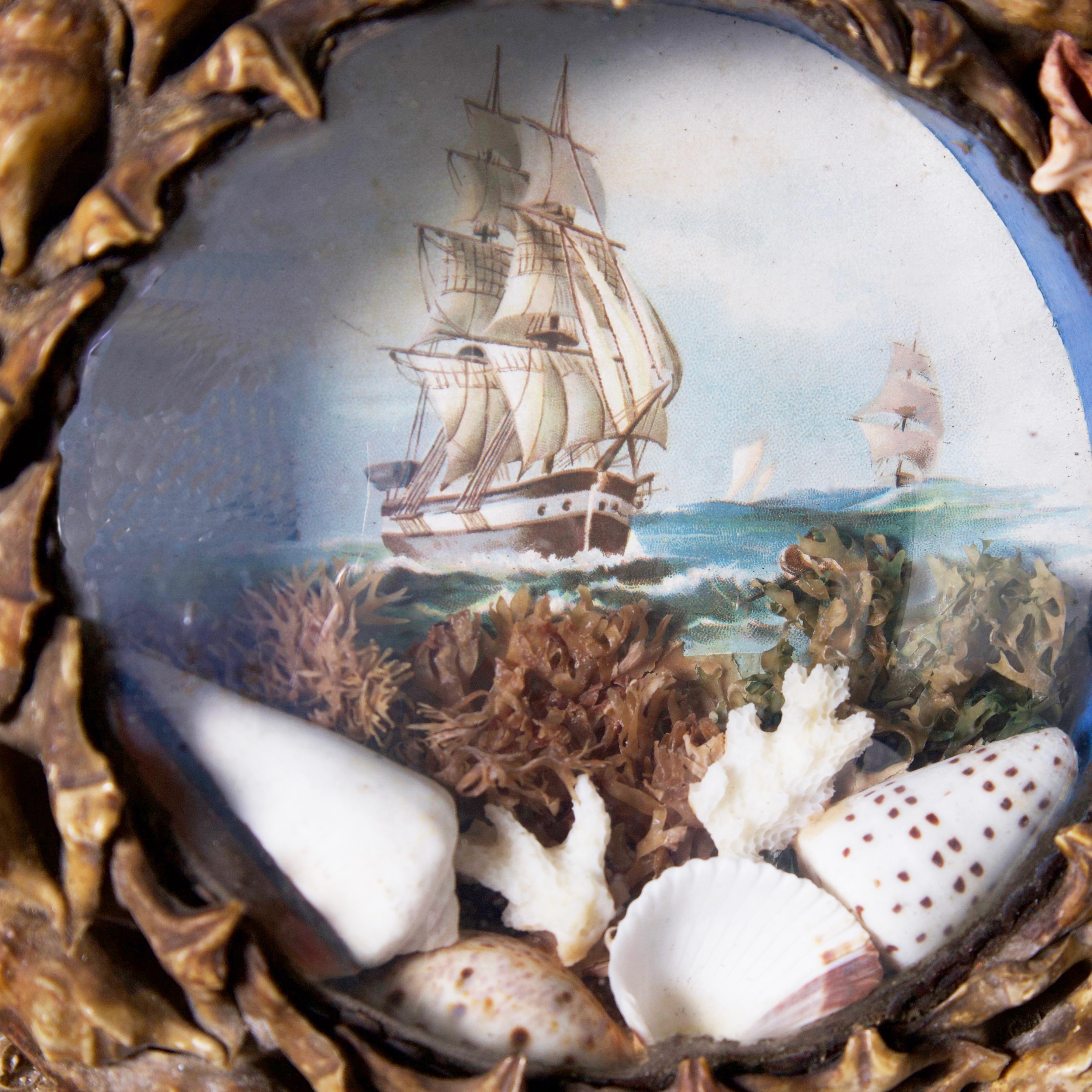 Enchanting 19th century English sailors valentine with a sailing ship image with shells and coral under a convex lens inside a frame lovingly composed in exotic seashells.