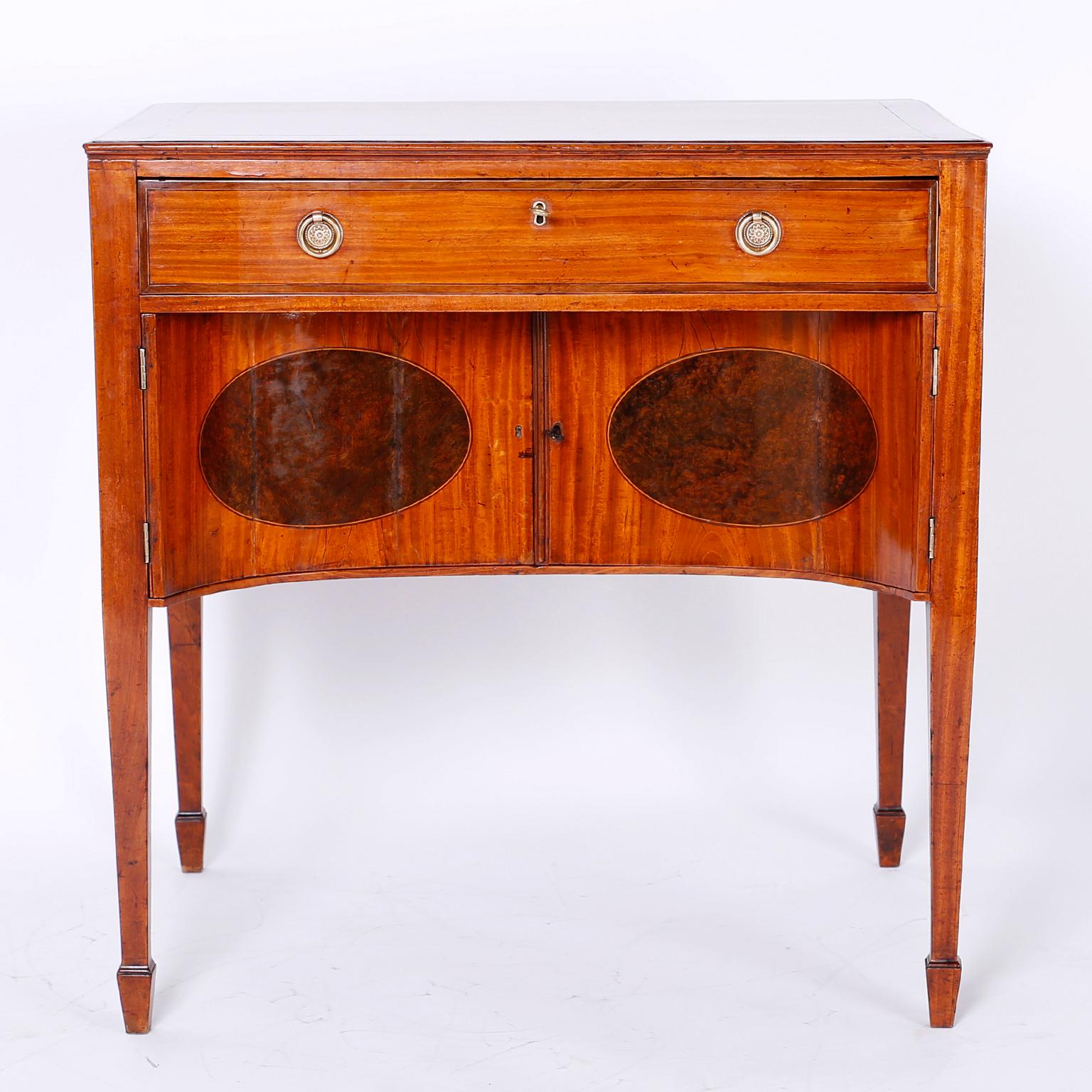 George 111 style dressing table featuring satinwood panels on the top, drawer front and doors which are highlighted with oval burl wood inlays.