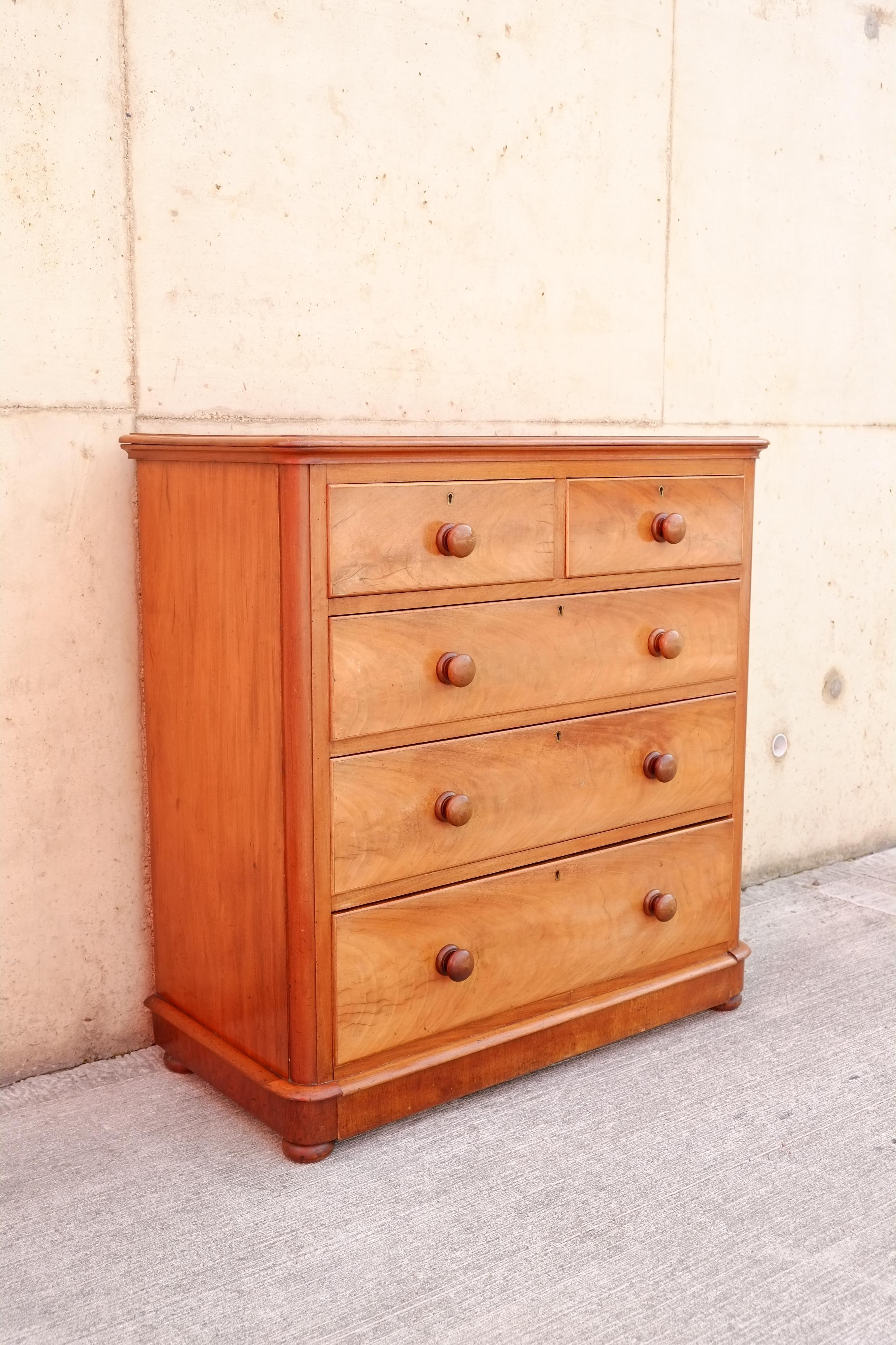 Un'elegante cassettiera inglese vittoriana in legno di raso. Questa cassettiera antica originale inglese ha cinque cassetti con un cassetto inferiore extra profondo incorporato nella base a zoccolo. Bellissimo legno satinato con un bel colore