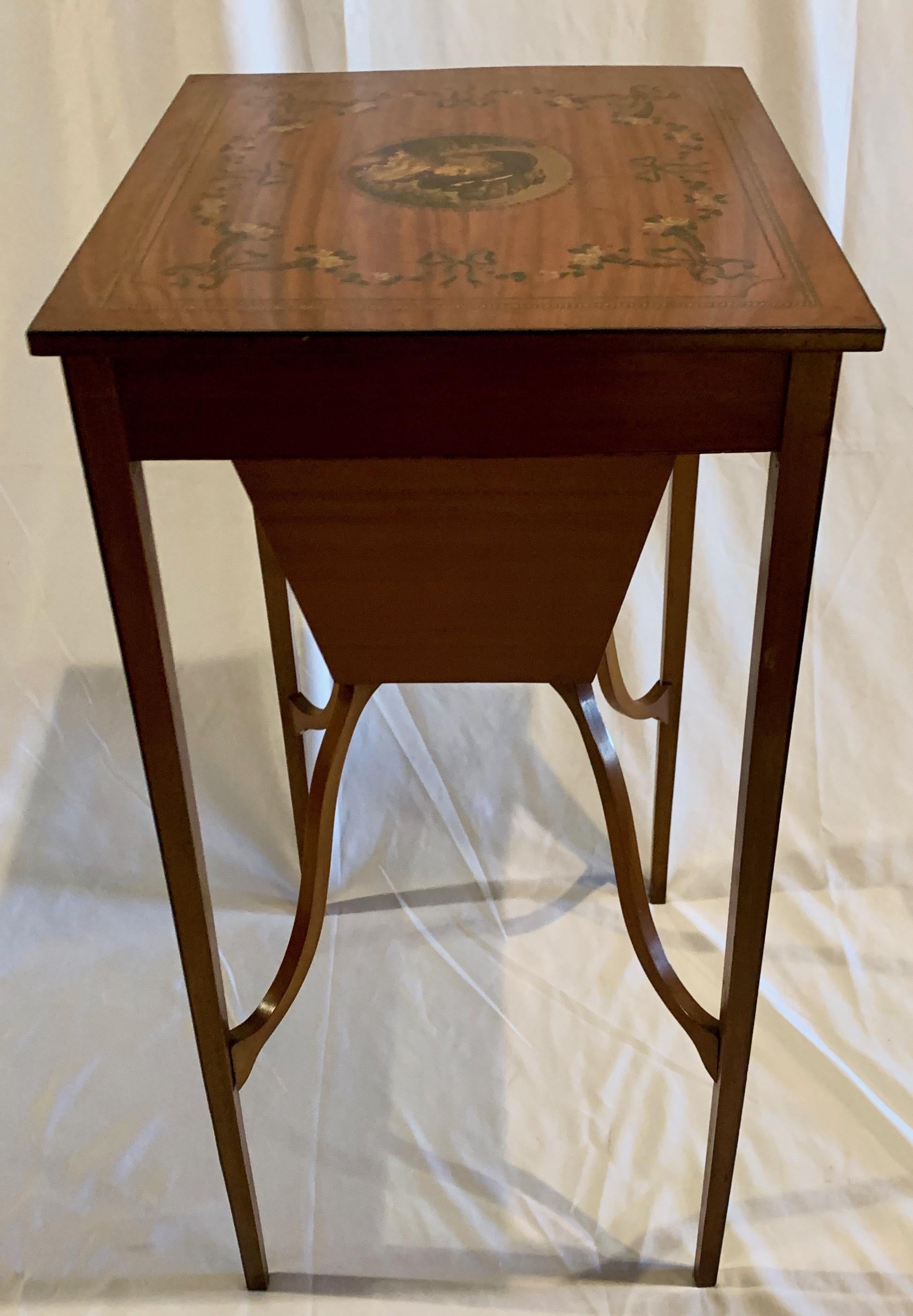 This sewing table is lovely and beautifully decorated, with the floral garlands surrounding a very well-outfitted lady sporting a large hat with plumage. There is plenty of storage in the sewing drawer and the satinwood's color is soft and